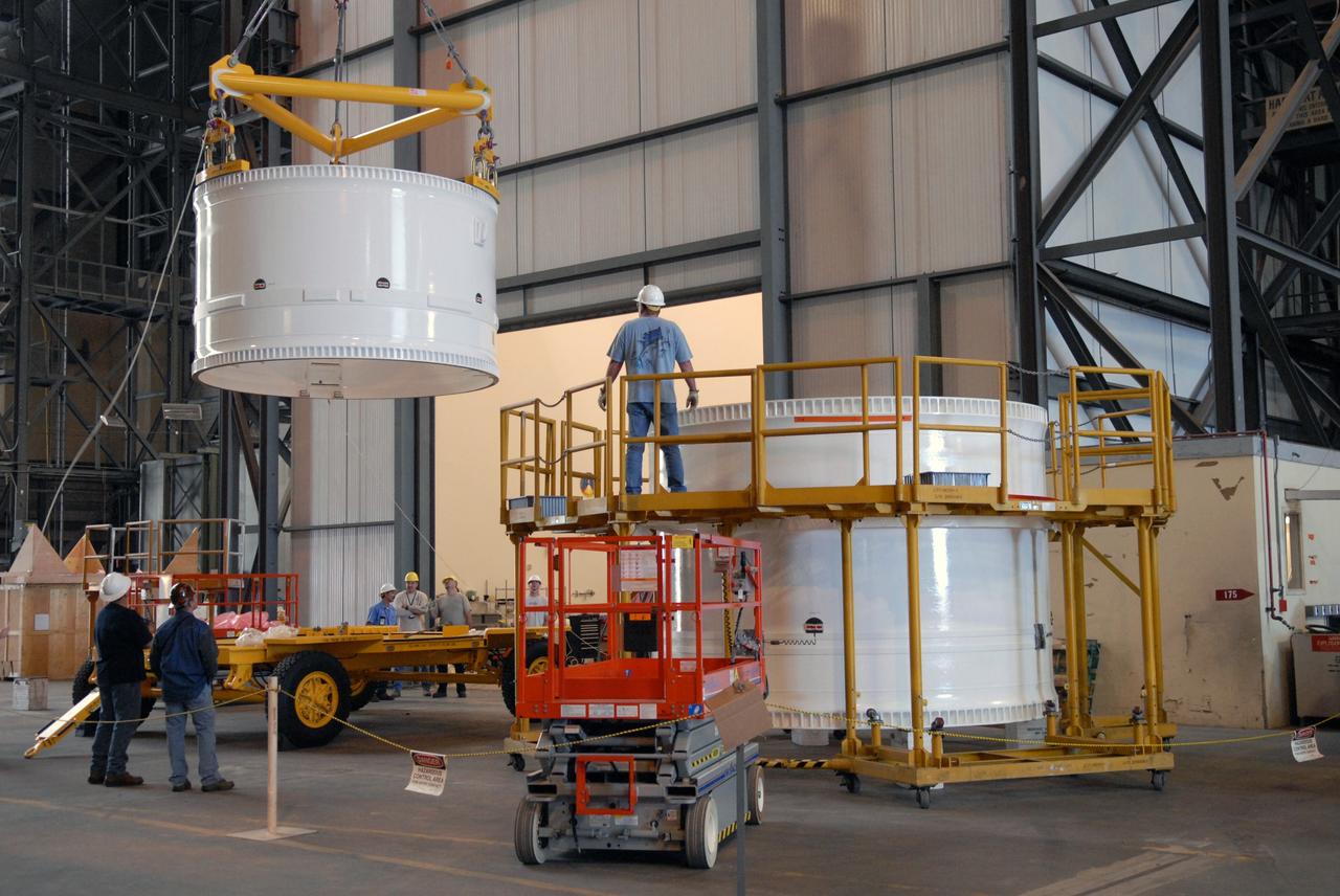 CAPE CANAVERAL, Fla. – In the Vehicle Assembly Building, the forward fifth segment simulator for the Ares I-X rocket is lifted toward the center segment beside it for stacking.  Ares I-X is the test vehicle for the Ares I, which is part of the Constellation Program to return men to the moon and beyond. Ares I is the essential core of a safe, reliable, cost-effective space transportation system that eventually will carry crewed missions back to the moon, on to Mars and out into the solar system. Ares I-X is targeted for launch in July 2009.  Photo credit: NASA/Dimitri Gerondidakis