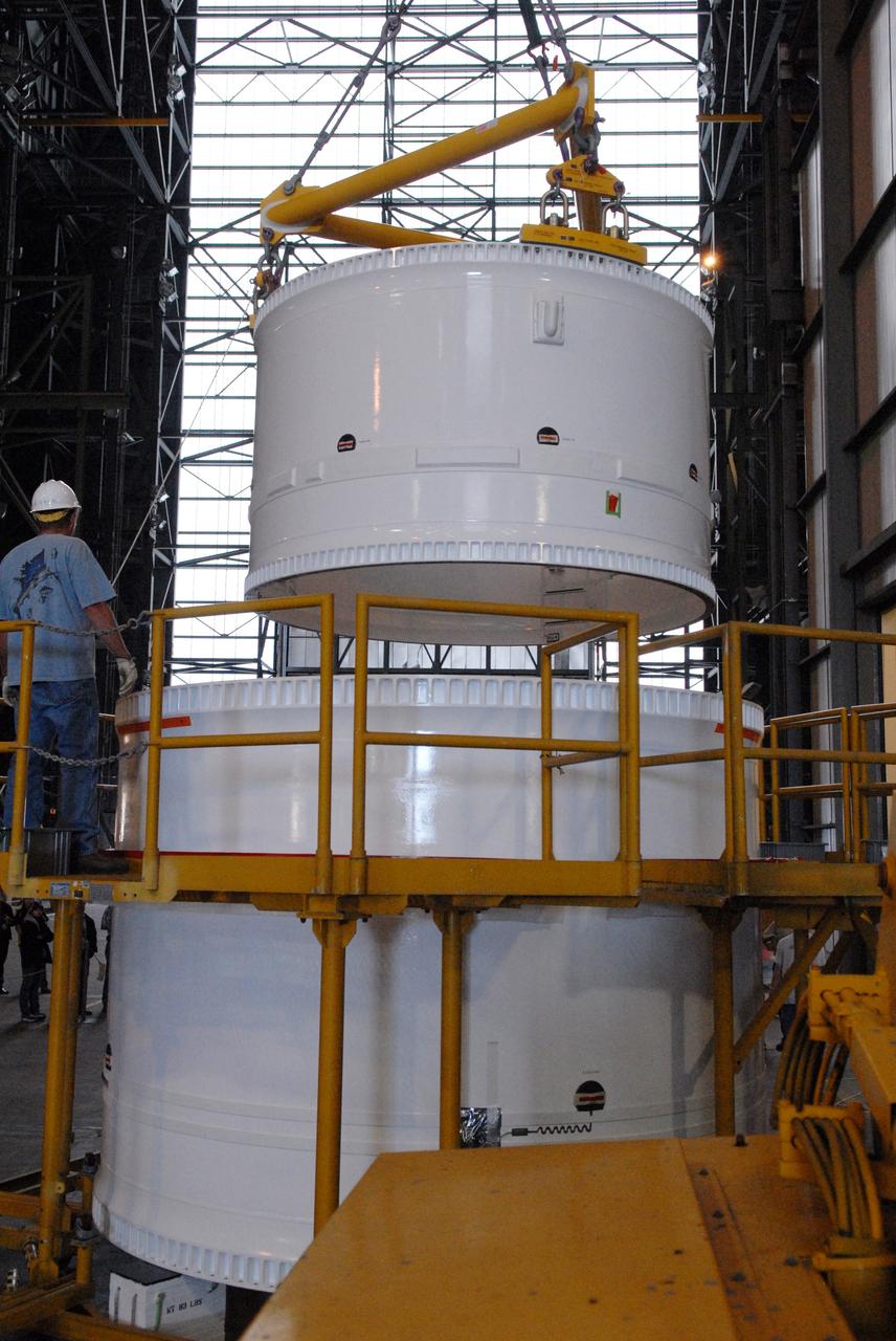 CAPE CANAVERAL, Fla. – In the Vehicle Assembly Building, the forward fifth segment simulator for the Ares I-X rocket is lowered toward the center segment for stacking. Ares I-X is the test vehicle for the Ares I, which is part of the Constellation Program to return men to the moon and beyond. Ares I is the essential core of a safe, reliable, cost-effective space transportation system that eventually will carry crewed missions back to the moon, on to Mars and out into the solar system. Ares I-X is targeted for launch in July 2009.  Photo credit: NASA/Dimitri Gerondidakis