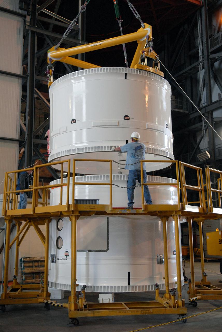 CAPE CANAVERAL, Fla. – In the Vehicle Assembly Building, the forward fifth segment simulator for the Ares I-X rocket is lowered toward the center segment for stacking. Ares I-X is the test vehicle for the Ares I, which is part of the Constellation Program to return men to the moon and beyond. Ares I is the essential core of a safe, reliable, cost-effective space transportation system that eventually will carry crewed missions back to the moon, on to Mars and out into the solar system. Ares I-X is targeted for launch in July 2009.  Photo credit: NASA/Dimitri Gerondidakis