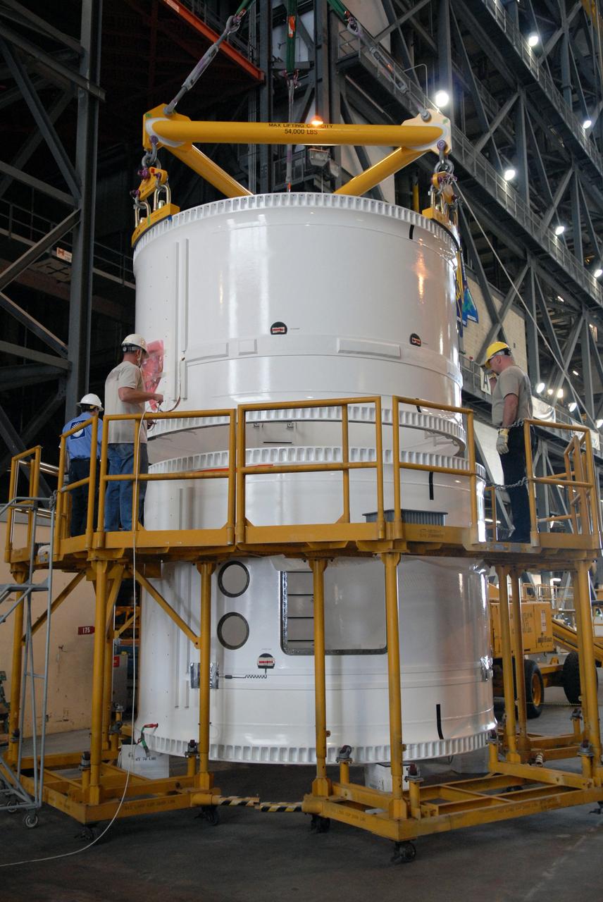 CAPE CANAVERAL, Fla. – In the Vehicle Assembly Building, technicians ensure the forward fifth segment simulator for the Ares I-X rocket is lowered in the proper position on the center segment.  Ares I-X is the test vehicle for the Ares I, which is part of the Constellation Program to return men to the moon and beyond. Ares I is the essential core of a safe, reliable, cost-effective space transportation system that eventually will carry crewed missions back to the moon, on to Mars and out into the solar system. Ares I-X is targeted for launch in July 2009.  Photo credit: NASA/Dimitri Gerondidakis