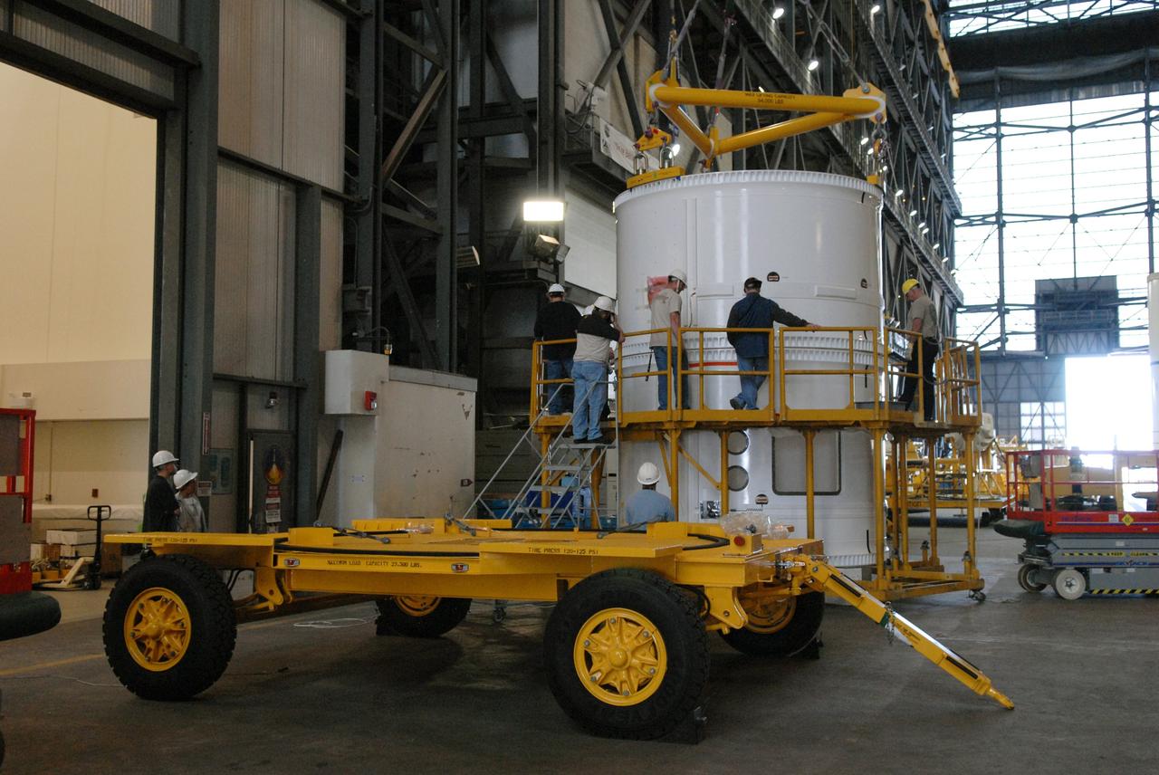 CAPE CANAVERAL, Fla. – In the Vehicle Assembly Building, technicians ensure the forward fifth segment simulator for the Ares I-X rocket is stacked correctly on the center segment. Ares I-X is the test vehicle for the Ares I, which is part of the Constellation Program to return men to the moon and beyond. Ares I is the essential core of a safe, reliable, cost-effective space transportation system that eventually will carry crewed missions back to the moon, on to Mars and out into the solar system. Ares I-X is targeted for launch in July 2009.  Photo credit: NASA/Dimitri Gerondidakis