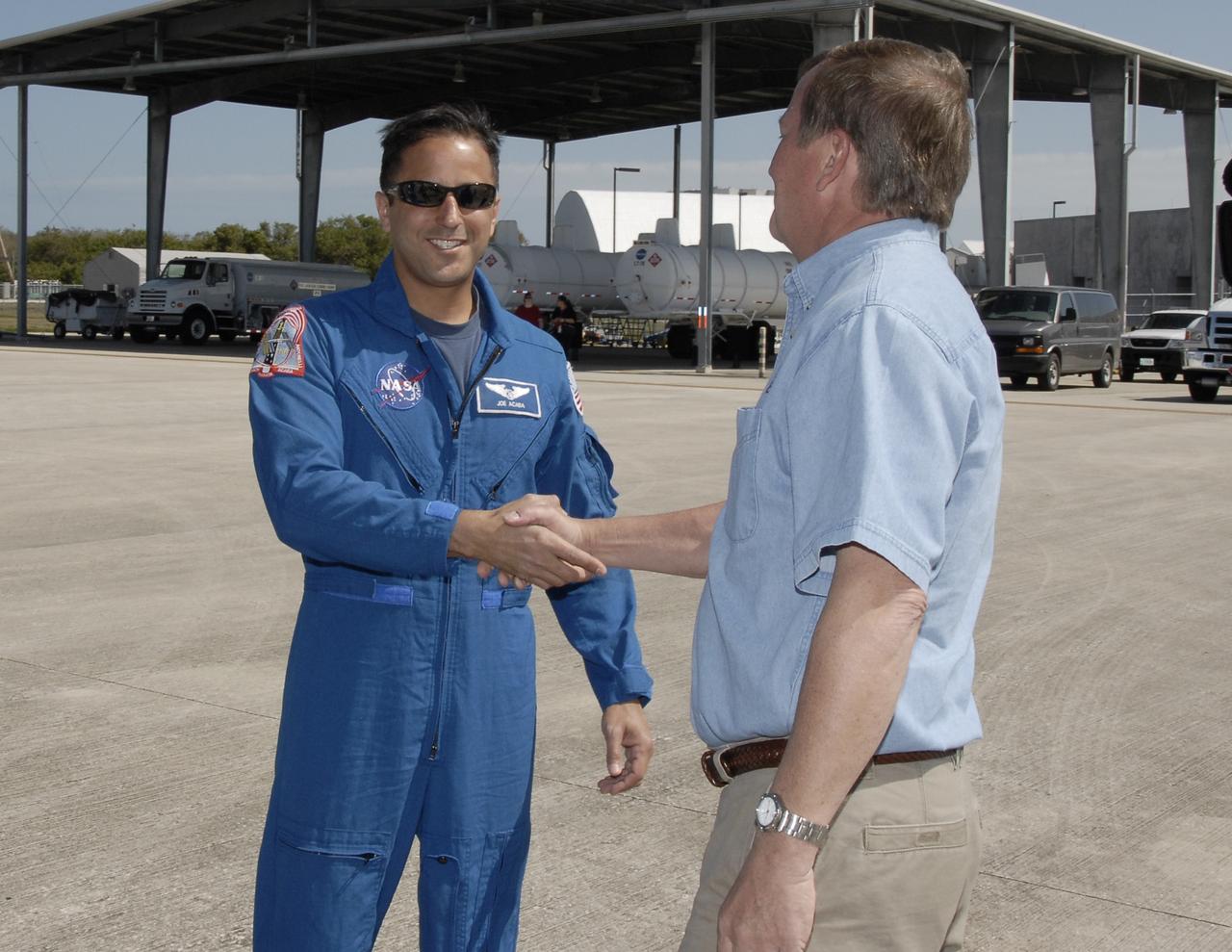 CAPE CANAVERAL, Fla. – The first crew members for space shuttle Discovery's STS-119 mission arrive at NASA's Kennedy Space Center in Florida to prepare for launch. From left, Mission Specialist Joseph Acaba is greeted by Mike Leinbach, shuttle launch director. STS-119 is the 125th space shuttle flight and the 28th flight to the International Space Station. Discovery and its crew will deliver the final set of large power-generating solar array wings and integrated truss structure, S6, to the space station. The mission includes four spacewalks. Launch is scheduled for March 11 at 9:20 p.m. EDT. Photo credit: NASA/Kim Shiflett