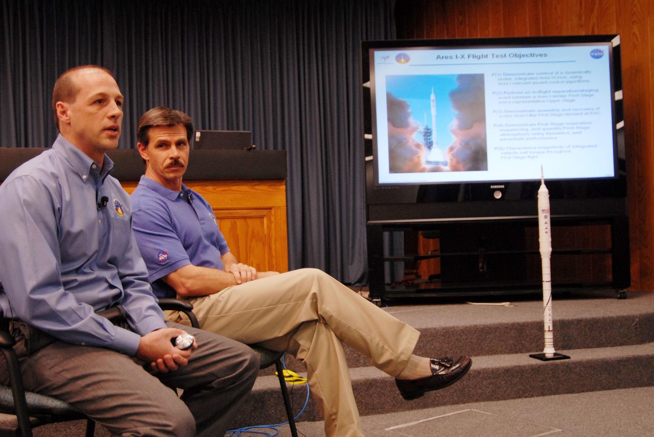 CAPE CANAVERAL, Fla. – Media were invited to a showing of the Ares I-X simulator rocket segments at NASA's Kennedy Space Center in Florida. Here, Bob Ess and Jon Cowart discuss the flight test objectives of the Ares I-X targeted for launch in July 2009.  Ess is manager of the Ares I-X project. Cowart is Ares I-X deputy mission manager.  The I-X flight will provide NASA an early opportunity to test and prove hardware, facilities and ground operations associated with Ares I,  part of the Constellation Program to return men to the moon and beyond. Ares I is the essential core of a safe, reliable, cost-effective space transportation system that eventually will carry crewed missions back to the moon, on to Mars and out into the solar system. Photo credit: NASA/Jack Pfaller