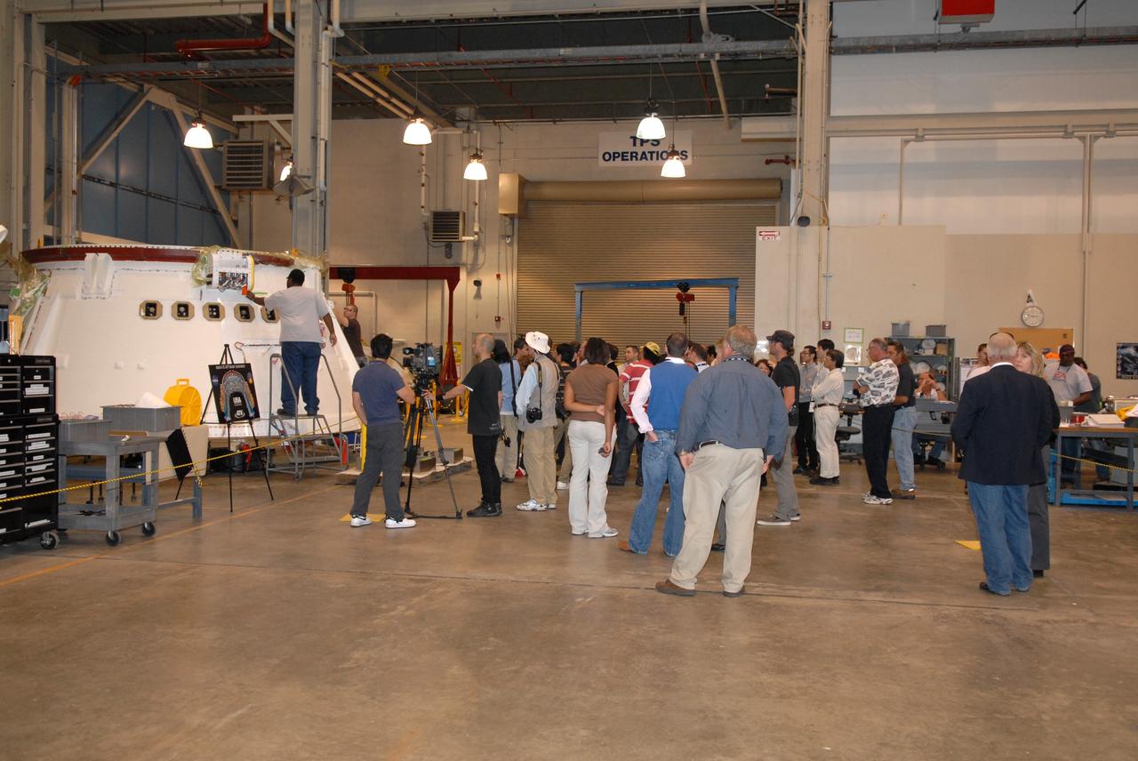 CAPE CANAVERAL, Fla. – Media gather in the Assembly and Refurbishment Facility at NASA's Kennedy Space Center in Florida to see the aft skirt for the Ares I-X flight test, targeted for launch in July 2009.  The I-X flight will provide NASA an early opportunity to test and prove hardware, facilities and ground operations associated with Ares I,  part of the Constellation Program to return men to the moon and beyond. Ares I is the essential core of a safe, reliable, cost-effective space transportation system that eventually will carry crewed missions back to the moon, on to Mars and out into the solar system. Photo credit: NASA/Jack Pfaller