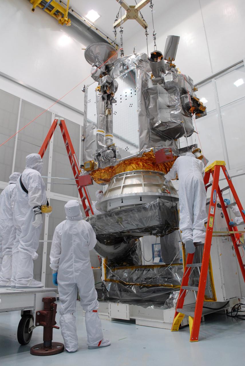 CAPE CANAVERAL, Fla. – At Astrotech in Titusville, Fla., an overhead crane lowers NASA's Lunar Reconnaissance Orbiter, or LRO, onto the Aronson table.  The orbiter will be rotated on the table to provide proper access for processing. The orbiter will carry seven instruments to provide scientists with detailed maps of the lunar surface and enhance our understanding of the moon's topography, lighting conditions, mineralogical composition and natural resources. Information gleaned from LRO will be used to select safe landing sites, determine locations for future lunar outposts and help mitigate radiation dangers to astronauts. The polar regions of the moon are the main focus of the mission because continuous access to sunlight may be possible and water ice may exist in permanently shadowed areas of the poles. Accompanying LRO on its journey to the moon will be the Lunar CRater Observation and Sensing Satellite, or LCROSS, a mission that will impact the lunar surface in its search for water ice. Launch of LRO is targeted for May 20.   Photo credit: NASA/Jack Pfaller