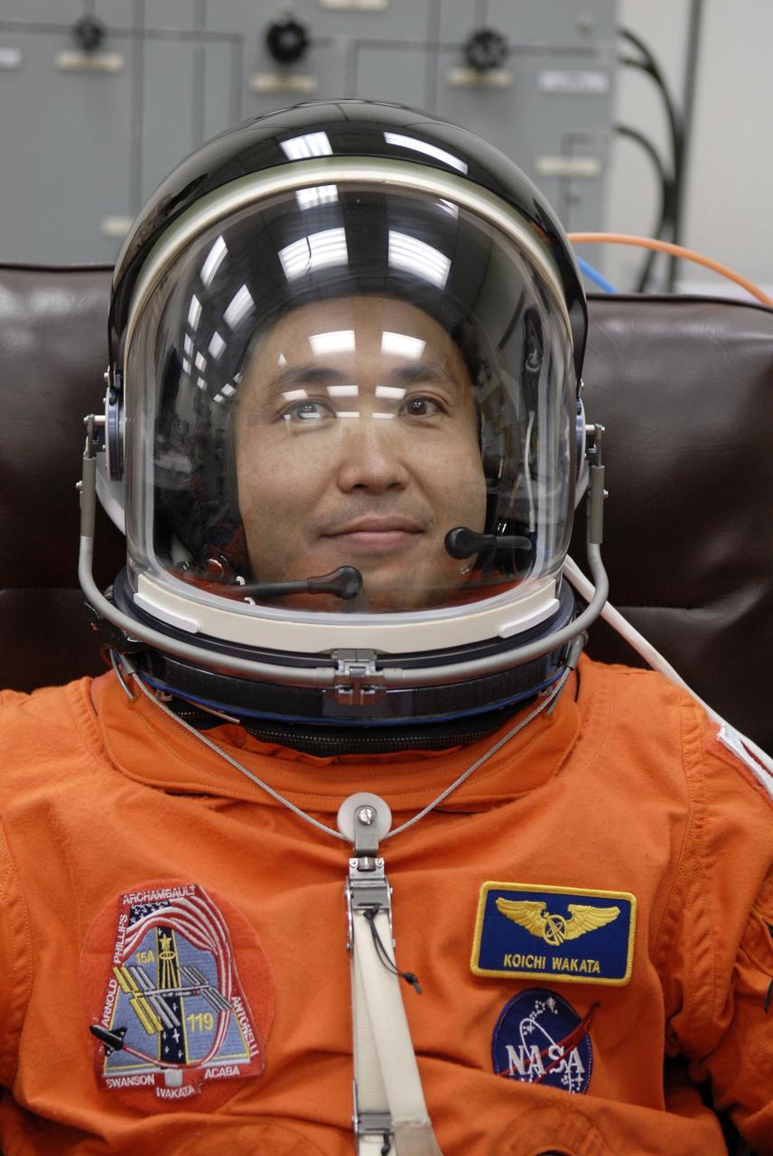 CAPE CANAVERAL, Fla. – In the Operations and Checkout Building at NASA's Kennedy Space Center in Florida, STS-119 Mission Specialist Koichi Wakata puts on his helmet as part of the final fitting of his launch and entry suit. Wakata is making his third shuttle flight. He will remain on the station, replacing Expedition 18 Flight Engineer Sandra Magnus, who returns to Earth with the STS-119 crew. The 14-day mission is the 28th to the International Space Station and the 125th space shuttle flight. Discovery will deliver the final pair of power-generating solar array wings and the S6 truss segment. Installation of S6 will signal the station's readiness to house a six-member crew for conducting increased science. Liftoff of Discovery is scheduled for 9:20 p.m. EDT on March 11. Photo credit: NASA/Kim Shiflett