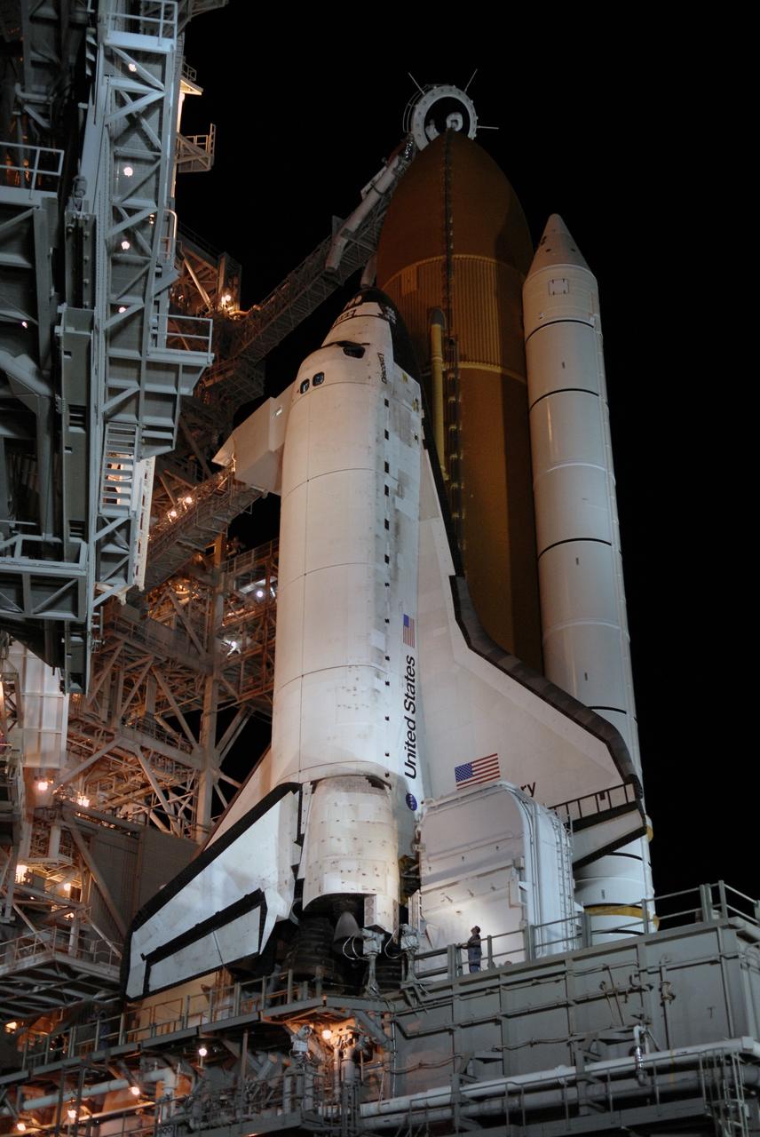 CAPE CANAVERAL, Fla. – On Launch Pad 39A at NASA's Kennedy Space Center in Florida, the orbiter access arm and White Room are extended toward space shuttle Discovery after rollback of the rotating service structure.  Above the external tank is the oxygen vent hood, called the "beanie cap."  The rollback is in preparation for Discovery's liftoff on the STS-119 mission with a crew of seven. The rotating structure provides protected access to the shuttle for changeout and servicing of payloads at the pad. After the RSS is rolled back, the orbiter is ready for fuel cell activation and external tank cryogenic propellant loading operations. The mission is the 28th to the International Space Station and the 125th space shuttle flight.  Discovery will deliver the final pair of power-generating solar array wings and the S6 truss segment.  Installation of S6 will signal the station's readiness to house a six-member crew for conducting increased science.  Liftoff of Discovery is scheduled for 9:20 p.m. EDT on March 11.   Photo credit: NASA/Kim Shiflett