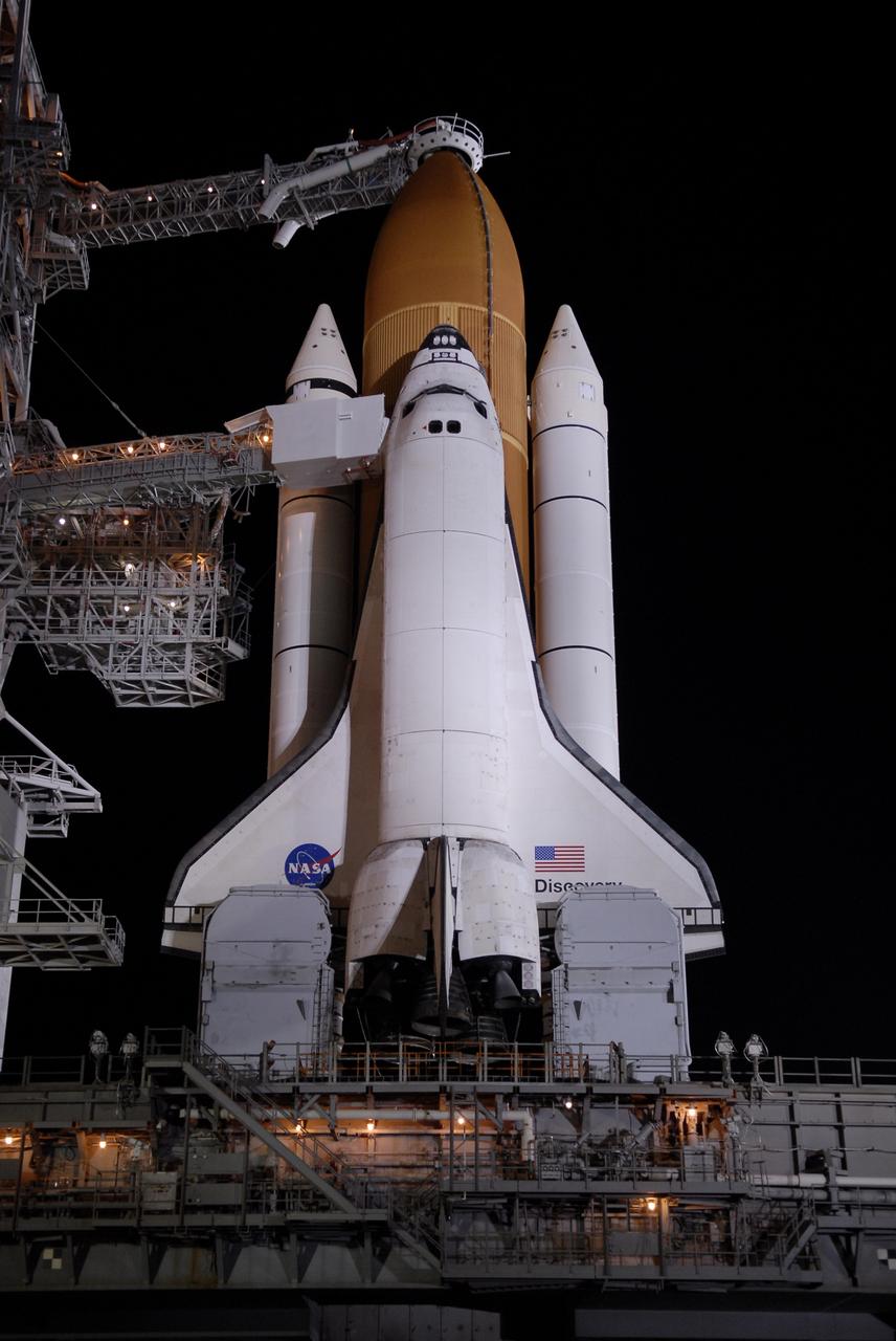 CAPE CANAVERAL, Fla. – On Launch Pad 39A at NASA's Kennedy Space Center in Florida, the orbiter access arm and White Room are extended toward space shuttle Discovery after rollback of the rotating service structure. The White Room provides crew access into the shuttle. Above the external tank is the oxygen vent hood, called the "beanie cap." The rollback is in preparation for Discovery's liftoff on the STS-119 mission with a crew of seven. The rotating structure provides protected access to the shuttle for changeout and servicing of payloads at the pad. After the RSS is rolled back, the orbiter is ready for fuel cell activation and external tank cryogenic propellant loading operations. The mission is the 28th to the International Space Station and the 125th space shuttle flight.  Discovery will deliver the final pair of power-generating solar array wings and the S6 truss segment.  Installation of S6 will signal the station's readiness to house a six-member crew for conducting increased science.  Liftoff of Discovery is scheduled for 9:20 p.m. EDT on March 11.   Photo credit: NASA/Kim Shiflett