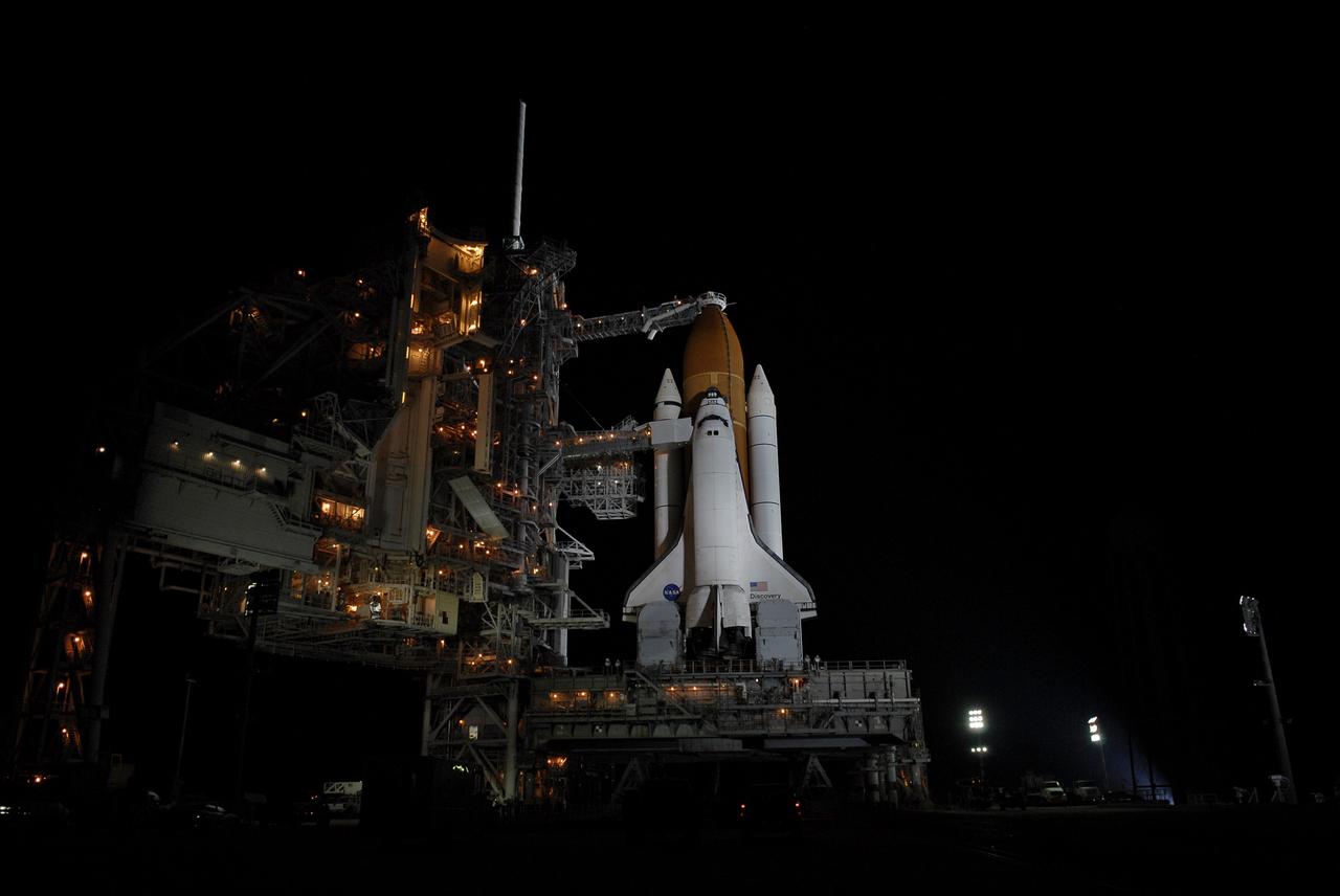 CAPE CANAVERAL, Fla. – Lights bathe space shuttle Discovery on Launch Pad 39A at NASA's Kennedy Space Center in Florida after rollback of the rotating service structure. The orbiter access arm and White Room are extended toward Discovery. The White Room provides crew access into the shuttle. Above the external tank is the oxygen vent hood, called the "beanie cap."  The rollback is in preparation for Discovery's liftoff on the STS-119 mission with a crew of seven. The rotating structure provides protected access to the shuttle for changeout and servicing of payloads at the pad. After the RSS is rolled back, the orbiter is ready for fuel cell activation and external tank cryogenic propellant loading operations. The mission is the 28th to the International Space Station and the 125th space shuttle flight.  Discovery will deliver the final pair of power-generating solar array wings and the S6 truss segment.  Installation of S6 will signal the station's readiness to house a six-member crew for conducting increased science.  Liftoff of Discovery is scheduled for 9:20 p.m. EDT on March 11.   Photo credit: NASA/Kim Shiflett