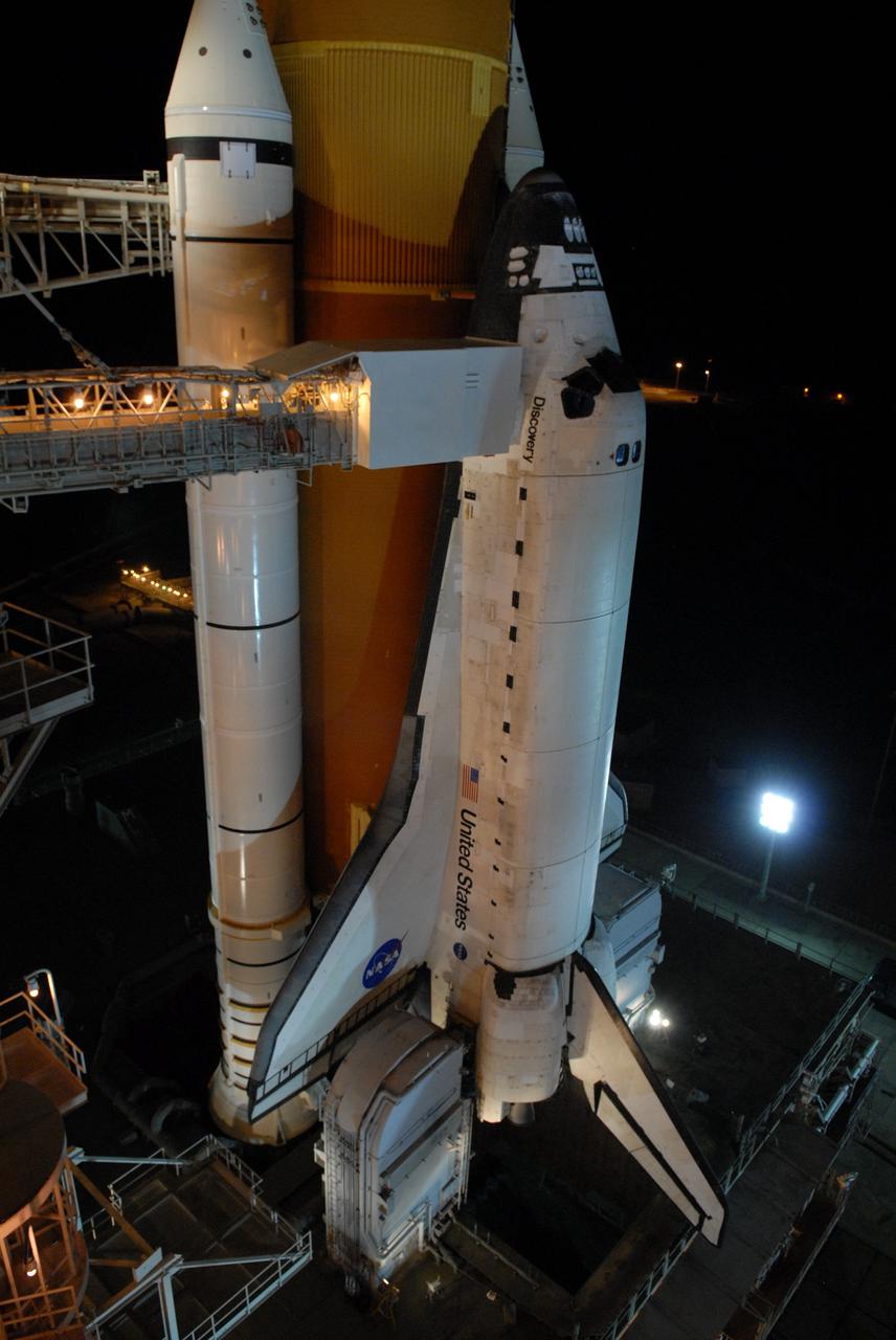 CAPE CANAVERAL, Fla. – On Launch Pad 39A at NASA's Kennedy Space Center in Florida, the orbiter access arm and White Room are extended toward space shuttle Discovery after rollback of the rotating service structure. The White Room provides crew access into the shuttle. The rollback is in preparation for Discovery's liftoff on the STS-119 mission with a crew of seven. An earlier launch attempt March 11 was scrubbed at 2:36 p.m. due to a gaseous hydrogen leak from the external tank at the Ground Umbilical Carrier Plate during tanking. A seven-inch quick disconnect and two seals were replaced. The STS-119 mission is the 28th to the International Space Station and the 125th space shuttle flight.  Discovery will deliver the final pair of power-generating solar array wings and the S6 truss segment.  Installation of S6 will signal the station's readiness to house a six-member crew for conducting increased science.  Liftoff of Discovery is scheduled for 7:43 p.m. EDT on March 15.   Photo credit: NASA/Jack Pfaller