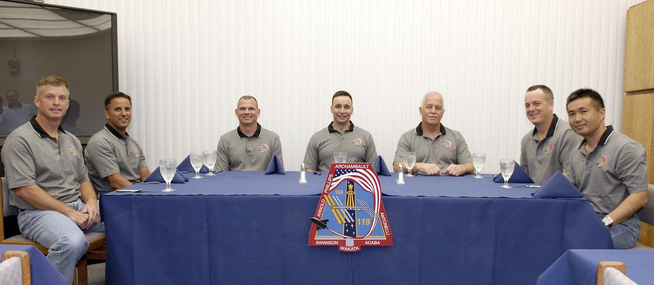 CAPE CANAVERAL, Fla. – Honoring tradition, the crew of space shuttle Discovery's STS-119 mission pose for a photo at the breakfast table at NASA's Kennedy Space Center in Florida. From left are Mission Specialists Steve Swanson, Joseph Acaba, Pilot Tony Antonelli, Commander Lee Archambault, and Mission Specialists John Phillips, Richard Arnold and Koichi Wakata, who represents the Japan Aerospace Exploration Agency.  Following the meal, the crew  members will put on their launch-and-entry suits and head for Launch Pad 39A. An earlier launch attempt March 11 was scrubbed at 2:36 p.m. due to a gaseous hydrogen leak from the external tank at the Ground Umbilical Carrier Plate during tanking. A seven-inch quick disconnect and two seals were replaced. The STS-119 mission is the 28th to the International Space Station and the 125th space shuttle flight.  Discovery will deliver the final pair of power-generating solar array wings and the S6 truss segment.  Installation of S6 will signal the station's readiness to house a six-member crew for conducting increased science.  Liftoff of Discovery is scheduled for 7:43 p.m. EDT on March 15.   Photo credit: NASA/Jack Pfaller