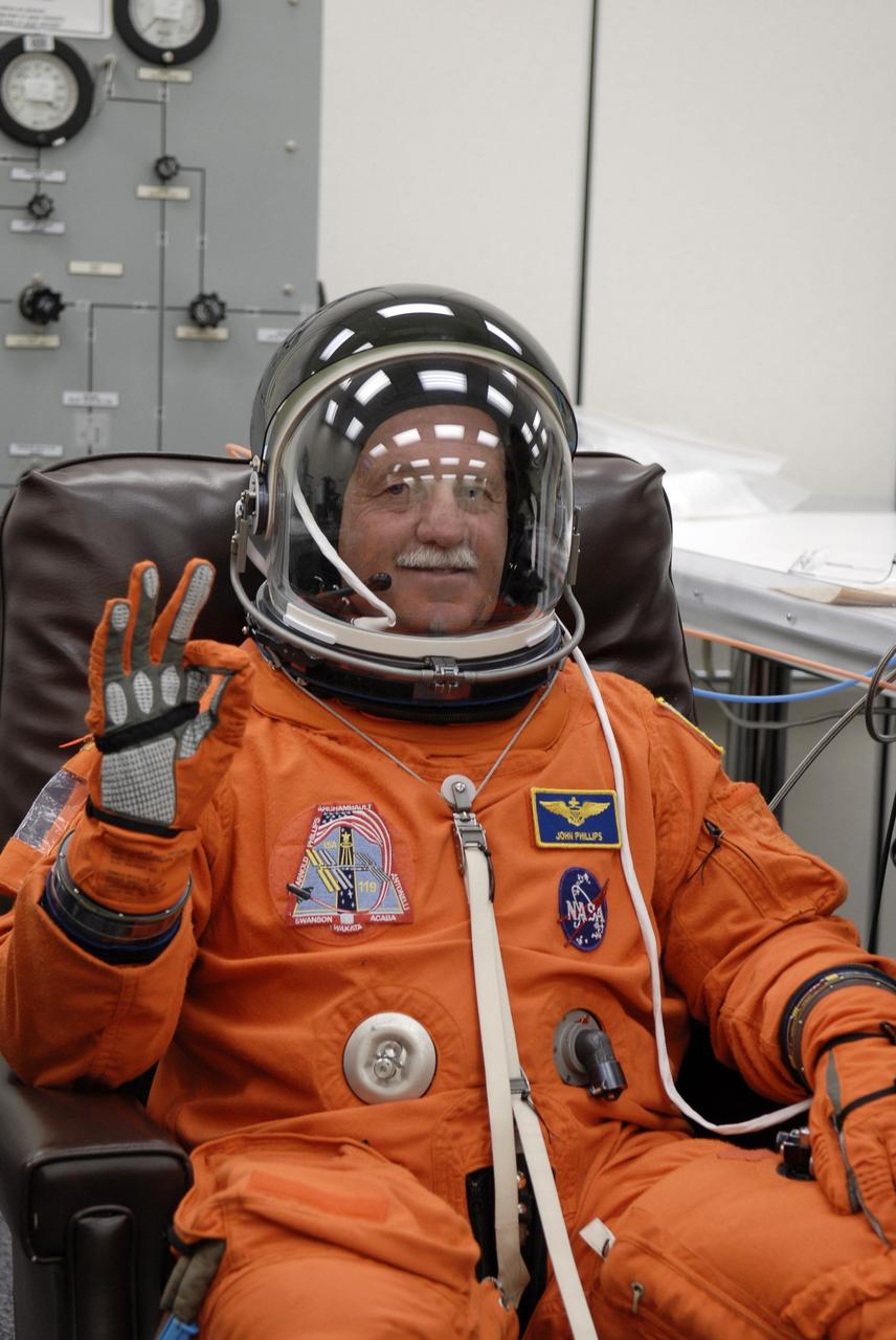 CAPE CANAVERAL, Fla. – In the Operations and Checkout Building at NASA's Kennedy Space Center in Florida, STS-119 Mission Specialist John Phillips  is eager for launch as he puts on his launch-and-entry suit.  The crew will be heading for Launch Pad 39A and liftoff of space shuttle Discovery, scheduled for 7:43 p.m. EDT on March 15.  An earlier launch attempt March 11 was scrubbed at 2:36 p.m. due to a gaseous hydrogen leak from the external tank at the Ground Umbilical Carrier Plate during tanking. A seven-inch quick disconnect and two seals were replaced. The STS-119 mission is the 28th to the International Space Station and the 125th space shuttle flight.  Discovery will deliver the final pair of power-generating solar array wings and the S6 truss segment.  Installation of S6 will signal the station's readiness to house a six-member crew for conducting increased science.  Photo credit: NASA/Kim Shiflett