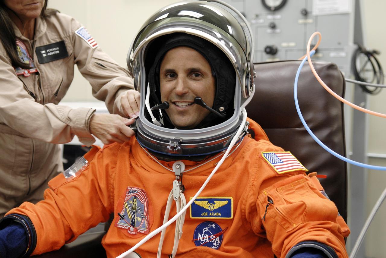 CAPE CANAVERAL, Fla. – In the Operations and Checkout Building at NASA's Kennedy Space Center in Florida, STS-119 Mission Specialist Joseph Acaba has his helmet fitted on his launch-and-entry suit.  The crew will be heading for Launch Pad 39A and liftoff of space shuttle Discovery, scheduled for 7:43 p.m. EDT on March 15.  An earlier launch attempt March 11 was scrubbed at 2:36 p.m. due to a gaseous hydrogen leak from the external tank at the Ground Umbilical Carrier Plate during tanking. A seven-inch quick disconnect and two seals were replaced. The STS-119 mission is the 28th to the International Space Station and the 125th space shuttle flight.  Discovery will deliver the final pair of power-generating solar array wings and the S6 truss segment.  Installation of S6 will signal the station's readiness to house a six-member crew for conducting increased science.  Photo credit: NASA/Kim Shiflett