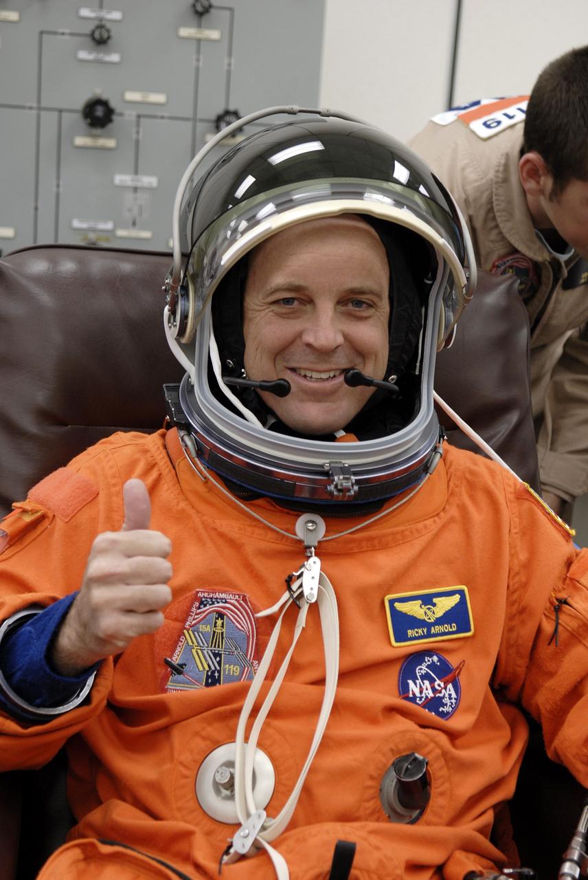 CAPE CANAVERAL, Fla. – In the Operations and Checkout Building at NASA's Kennedy Space Center in Florida, STS-119 Mission Specialist Richard Arnold completes putting on his launch-and-entry suit, including the helmet, for the launch of space shuttle Discovery.  The crew will be heading for Launch Pad 39A and liftoff of Discovery, scheduled for 7:43 p.m. EDT on March 15. An earlier launch attempt March 11 was scrubbed at 2:36 p.m. due to a gaseous hydrogen leak from the external tank at the Ground Umbilical Carrier Plate during tanking. A seven-inch quick disconnect and two seals were replaced. The STS-119 mission is the 28th to the International Space Station and the 125th space shuttle flight.  Discovery will deliver the final pair of power-generating solar array wings and the S6 truss segment.  Installation of S6 will signal the station's readiness to house a six-member crew for conducting increased science.  Photo credit: NASA/Kim Shiflett