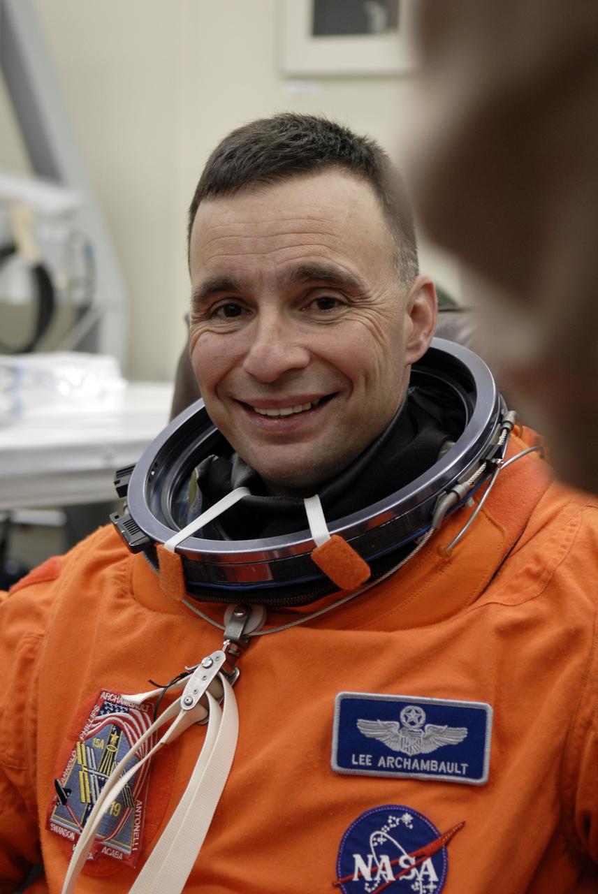CAPE CANAVERAL, Fla. – In the Operations and Checkout Building at NASA's Kennedy Space Center in Florida, STS-119 Commander Lee Archambault puts on his launch-and-entry suit for the launch of space shuttle Discovery.  The crew will be heading for Launch Pad 39A and liftoff of Discovery, scheduled for 7:43 p.m. EDT on March 15.   An earlier launch attempt March 11 was scrubbed at 2:36 p.m. due to a gaseous hydrogen leak from the external tank at the Ground Umbilical Carrier Plate during tanking. A seven-inch quick disconnect and two seals were replaced. The STS-119 mission is the 28th to the International Space Station and the 125th space shuttle flight.  Discovery will deliver the final pair of power-generating solar array wings and the S6 truss segment.  Installation of S6 will signal the station's readiness to house a six-member crew for conducting increased science.  Photo credit: NASA/Kim Shiflett