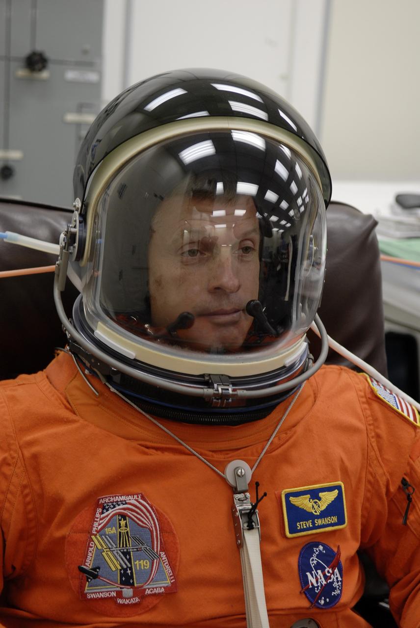 CAPE CANAVERAL, Fla. – In the Operations and Checkout Building at NASA's Kennedy Space Center in Florida, STS-119 Mission Specialist Steve Swanson completes putting on the launch-and-entry suit, with the helmet, for the launch of space shuttle Discovery.  The crew will be heading for Launch Pad 39A and liftoff of Discovery, scheduled for 7:43 p.m. EDT on March 15. An earlier launch attempt March 11 was scrubbed at 2:36 p.m. due to a gaseous hydrogen leak from the external tank at the Ground Umbilical Carrier Plate during tanking. A seven-inch quick disconnect and two seals were replaced. The STS-119 mission is the 28th to the International Space Station and the 125th space shuttle flight.  Discovery will deliver the final pair of power-generating solar array wings and the S6 truss segment.  Installation of S6 will signal the station's readiness to house a six-member crew for conducting increased science.  Photo credit: NASA/Kim Shiflett