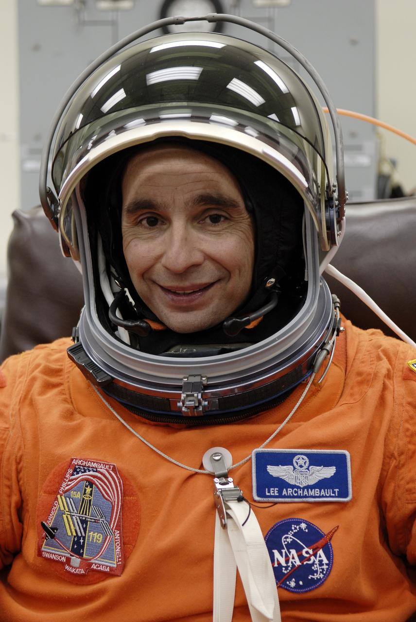 CAPE CANAVERAL, Fla. – In the Operations and Checkout Building at NASA's Kennedy Space Center in Florida, STS-119 Commander Lee Archambault fits the helmet on his launch-and-entry suit for the launch of space shuttle Discovery.  The crew will be heading for Launch Pad 39A and liftoff of Discovery, scheduled for 7:43 p.m. EDT on March 15. An earlier launch attempt March 11 was scrubbed at 2:36 p.m. due to a gaseous hydrogen leak from the external tank at the Ground Umbilical Carrier Plate during tanking. A seven-inch quick disconnect and two seals were replaced. The STS-119 mission is the 28th to the International Space Station and the 125th space shuttle flight.  Discovery will deliver the final pair of power-generating solar array wings and the S6 truss segment.  Installation of S6 will signal the station's readiness to house a six-member crew for conducting increased science.  Photo credit: NASA/Kim Shiflett