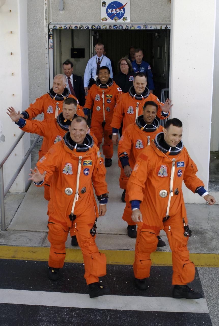 CAPE CANAVERAL, Fla. – The crew members of the STS-119 mission stride out of the Operations and Checkout Building at NASA's Kennedy Space Center in Florida, heading for the Astrovan that will take them to Launch Pad 39A.  Clockwise from left are Pilot Tony Antonelli, Mission Specialists Steve Swanson, John Phillips, Koichi Wakata, Richard Arnold and Joseph Acaba, and Commander Lee Archambault.  Wakata represents the Japan Aerospace Exploration Agency and will remain on the International Space Station, replacing Expedition 18 Flight Engineer Sandra Magnus, who returns to Earth with the STS-119 crew. Liftoff of Discovery is scheduled for 7:43 p.m. EDT.  The STS-119 mission is the 28th to the space station and the 125th space shuttle flight.  Discovery will deliver the final pair of power-generating solar array wings and the S6 truss segment.  Installation of S6 will signal the station's readiness to house a six-member crew for conducting increased science.  Photo credit: NASA/Kim Shiflett