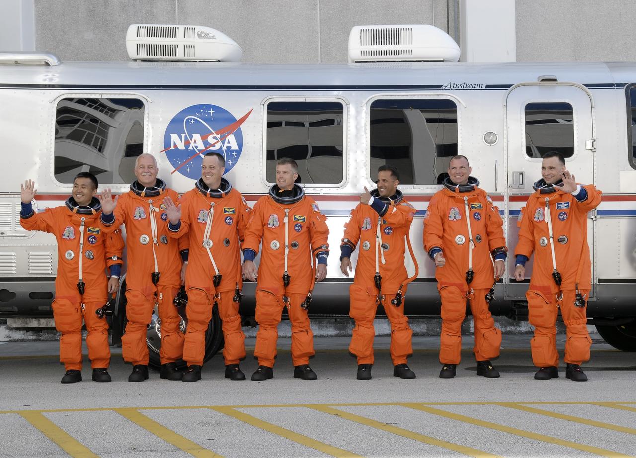 CAPE CANAVERAL, Fla. – The STS-119 crew members pause for photos before boarding the Astrovan to take them to Launch Pad 39A at NASA's Kennedy Space Center in Florida for launch of space shuttle Discovery to the International Space Station.  From left are Mission Specialists Koichi Wakata, John Phillips, Richard Arnold, Steve Swanson and Joseph Acaba, Pilot Tony Antonelli and Commander Lee Archambault. Wakata represents the Japan Aerospace Exploration Agency and will remain on the International Space Station, replacing Expedition 18 Flight Engineer Sandra Magnus, who returns to Earth with the STS-119 crew.  Liftoff of Discovery is scheduled for 7:43 p.m. EDT on March 15. An earlier launch attempt March 11 was scrubbed at 2:36 p.m. due to a gaseous hydrogen leak from the external tank at the Ground Umbilical Carrier Plate during tanking. A seven-inch quick disconnect and two seals were replaced. The STS-119 mission is the 28th to the space station and the 125th space shuttle flight.  Discovery will deliver the final pair of power-generating solar array wings and the S6 truss segment.  Installation of S6 will signal the station's readiness to house a six-member crew for conducting increased science.  Photo credit: NASA/Kim Shiflett