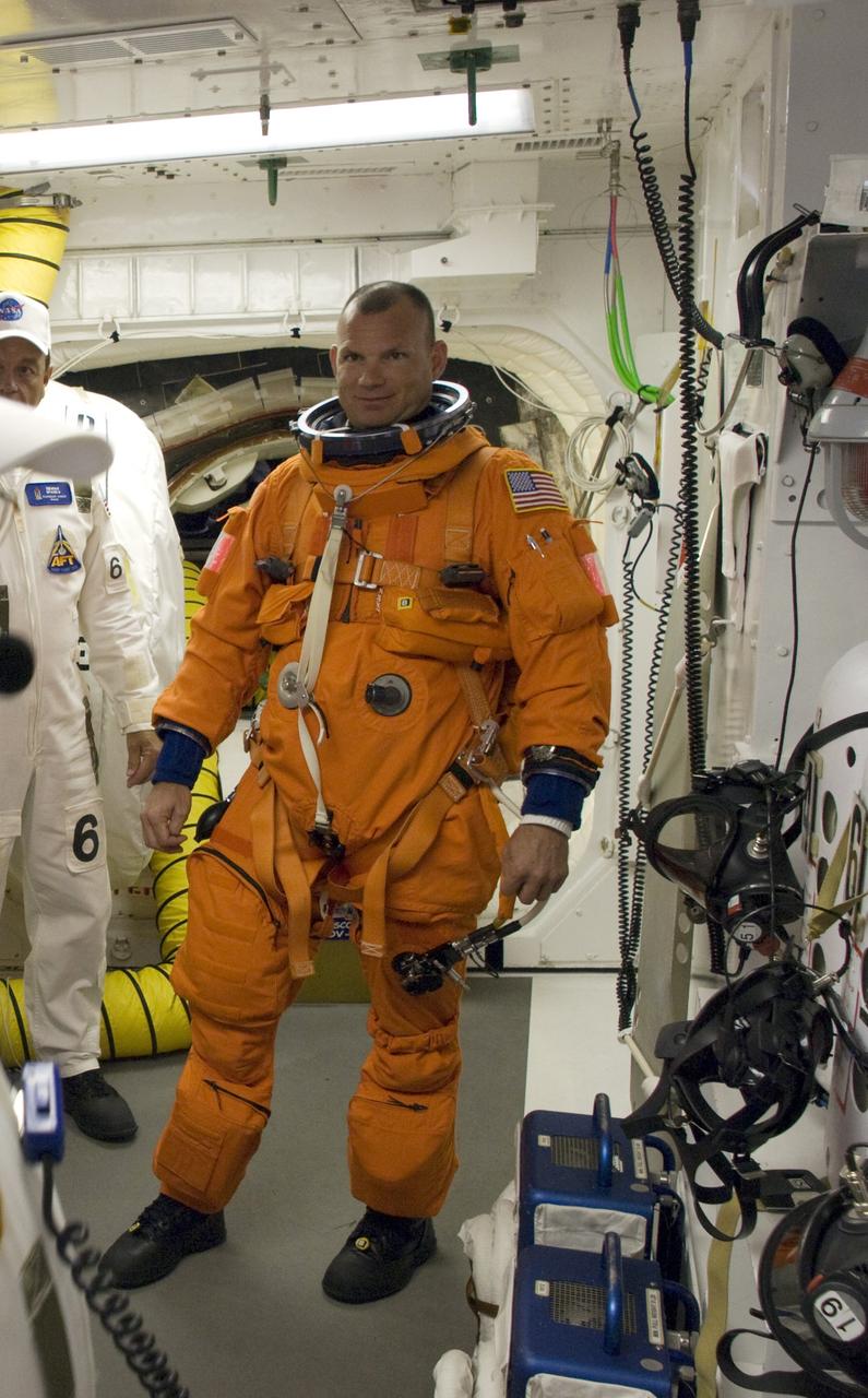 CAPE CANAVERAL, Fla. – In the White Room on Launch Pad 39A at NASA's Kennedy Space Center in Florida, STS-119 Pilot Tony Antonelli is getting into his harness, which includes a parachute pack, before crawling through the open hatch into space shuttle Discovery. The White Room is at the end of the orbiter access arm on the fixed service structure and provides access into the shuttle. The STS-119 mission is the 28th to the International Space Station and the 125th space shuttle flight.  Discovery will deliver the final pair of power-generating solar array wings and the S6 truss segment.  Installation of S6 will signal the station's readiness to house a six-member crew for conducting increased science. Liftoff is scheduled for 7:43 p.m. EDT. Photo credit: NASA/Tony Gray, Tom Farrar