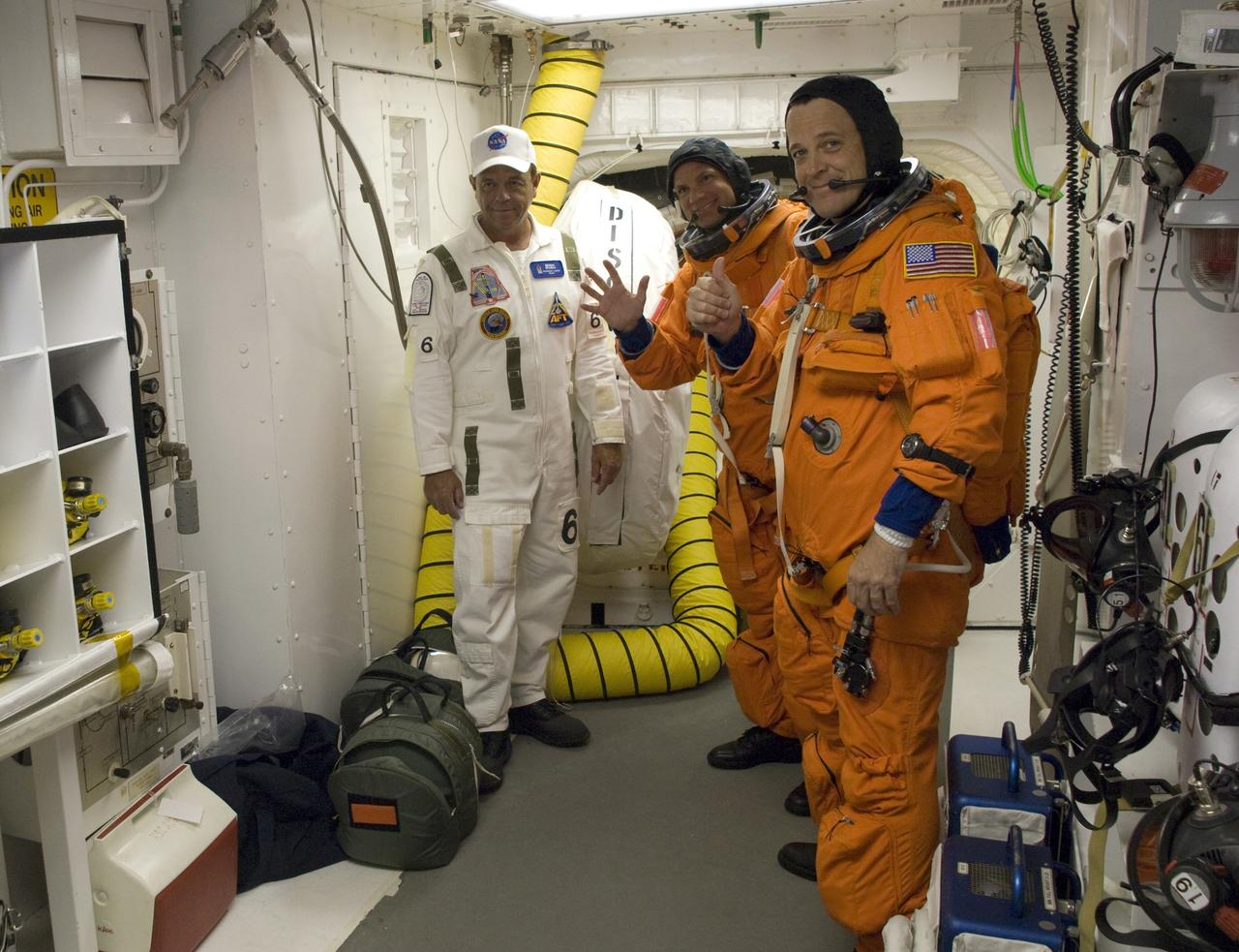 CAPE CANAVERAL, Fla. – In the White Room on Launch Pad 39A at NASA's Kennedy Space Center in Florida, STS-119 Pilot Tony Antonelli (center) and Mission Specialist Richard Arnold are getting ready to enter the open hatch into space shuttle Discovery. The White Room is at the end of the orbiter access arm on the fixed service structure and provides access into the shuttle. The STS-119 mission is the 28th to the International Space Station and the 125th space shuttle flight.  Discovery will deliver the final pair of power-generating solar array wings and the S6 truss segment.  Installation of S6 will signal the station's readiness to house a six-member crew for conducting increased science. Liftoff is scheduled for 7:43 p.m. EDT. Photo credit: NASA/Tony Gray, Tom Farrar