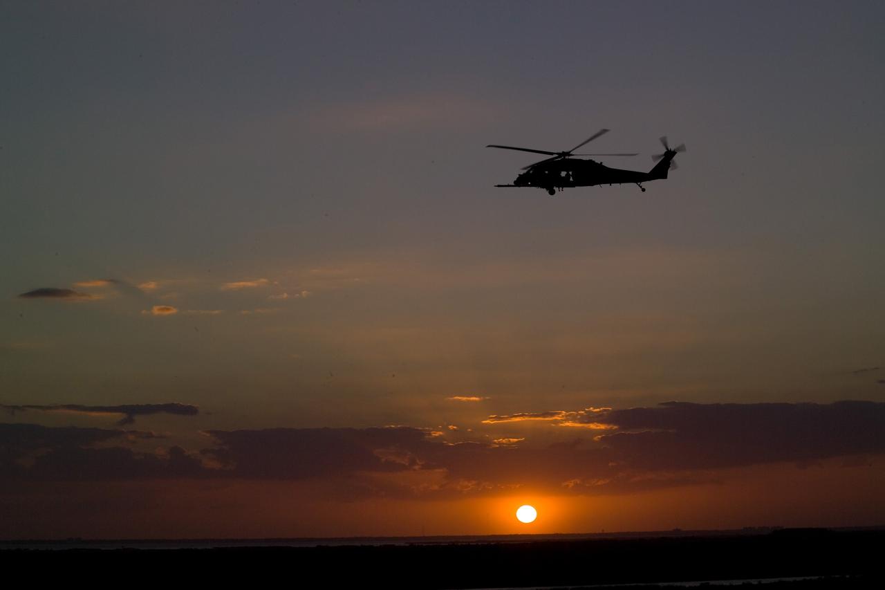 CAPE CANAVERAL, Fla. – A helicopter patrols the sky over NASA's Kennedy Space Center in Florida before launch of space shuttle Discovery on the STS-119 mission.  Liftoff of Discovery was on time at 7:43 p.m. EDT.  The STS-119 mission is the 28th to the International Space Station and the 125th space shuttle flight.  Discovery will deliver the final pair of power-generating solar array wings and the S6 truss segment.  Installation of S6 will signal the station's readiness to house a six-member crew for conducting increased science. Photo credit: NASA/Jeff Wolfe