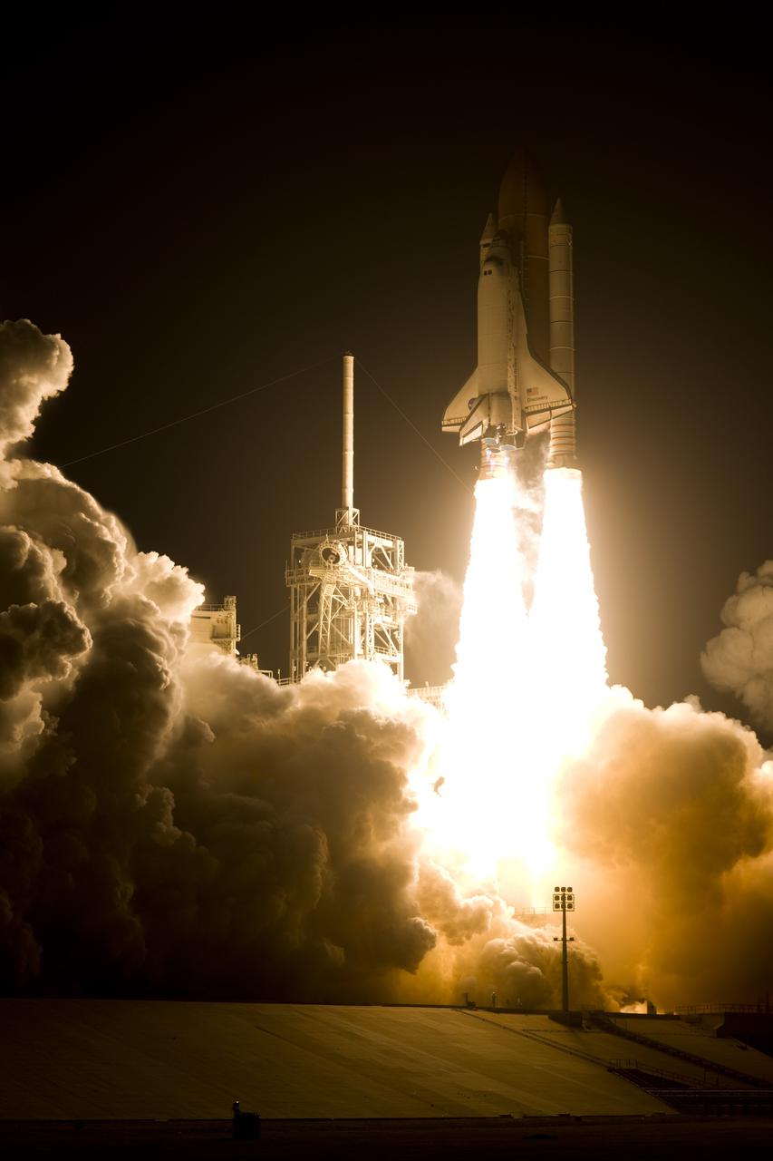 CAPE CANAVERAL, Fla. – At NASA's Kennedy Space Center in Florida, twin columns of fire propel space shuttle Discovery past the lightning mast on Launch Pad 39A toward space on mission STS-119.  Launch was on time at 7:43 p.m. EDT. The STS-119 mission is the 28th to the International Space Station and the 125th space shuttle flight.  Discovery will deliver the final pair of power-generating solar array wings and the S6 truss segment.  Installation of S6 will signal the station's readiness to house a six-member crew for conducting increased science.  Photo courtesy of Scott Andrews