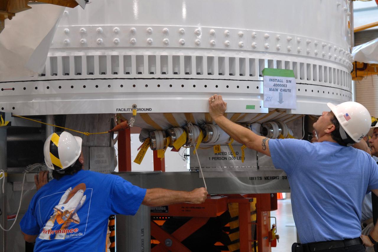 CAPE CANAVERAL, Fla. – In the Assembly and Refurbishment Facility at NASA's Kennedy Space Center in Florida, workers install a parachute pack in the Ares I-X forward skirt segment. The forward skirt is the initial piece of first-stage hardware in preparation for the July 2009 test flight of the agency's next-generation spacecraft and launch vehicle system.  Photo credit: NASA/Jack Pfaller