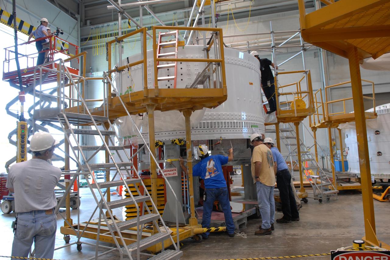 CAPE CANAVERAL, Fla. – In the Assembly and Refurbishment Facility at NASA's Kennedy Space Center in Florida, workers install a parachute pack in the Ares I-X forward skirt segment.  The forward skirt is the initial piece of first-stage hardware in preparation for the July 2009 test flight of the agency's next-generation spacecraft and launch vehicle system.  Photo credit: NASA/Jack Pfaller
