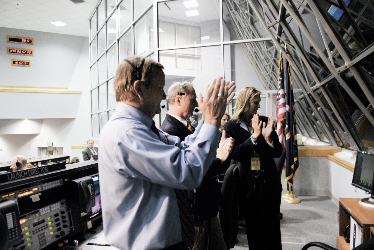 CAPE CANAVERAL, Fla. – In Firing Room 4 of the Launch Control Center at NASA's Kennedy Space Center in Florida, Shuttle Launch Director Mike Leinbach, Assistant Launch Director Pete Nickolenko and Flow Director for space shuttle Discovery Stephanie Stilson applaud the successful launch of space shuttle Discovery on the STS-119 mission.  Launch was on time at 7:43 p.m. EDT. The STS-119 mission is the 28th to the space station and Discovery's 36th flight.  Discovery will deliver the final pair of power-generating solar array wings and the S6 truss segment.  Installation of S6 will signal the station's readiness to house a six-member crew for conducting increased science.  Photo credit: NASA/Kim Shiflett