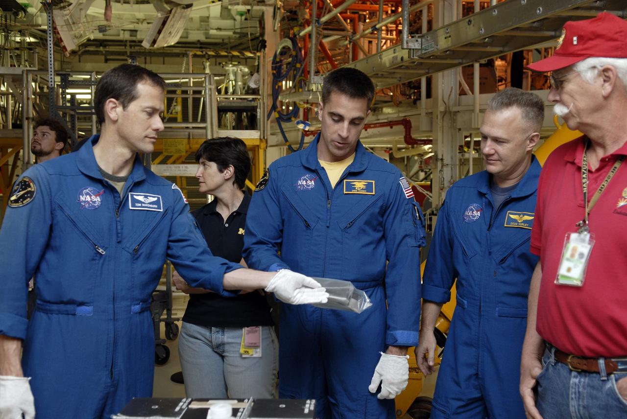 CAPE CANAVERAL, Fla. – In the Orbiter Processing Facility at NASA's Kennedy Space Center in Florida, STS-127 Mission Specialists Tom Marshburn and Christopher Cassidy and Pilot Doug Hurley get a close look at equipment that will be used on the mission to the International Space Station. The crew members are at Kennedy for a crew equipment interface test, which provides hands-on training and observation of shuttle and flight hardware. Endeavour will deliver the Japanese Experiment Module's Experiment Logistics Module-Exposed Section, or ELM-ES, to the space station on STS-127. Launch is targeted for mid-June, 2009. Photo credit: NASA/Kim Shiflett