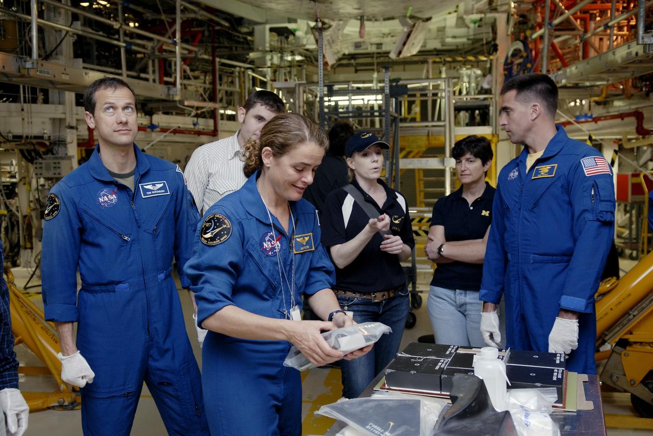 CAPE CANAVERAL, Fla. – In the Orbiter Processing Facility at NASA's Kennedy Space Center in Florida, STS-127 Mission Specialists (left) Tom Marshburn, Julie Payette and (right) Chris Cassidy get a close look at equipment that will be used on the mission to the International Space Station. The crew members are at Kennedy for a crew equipment interface test, which provides hands-on training and observation of shuttle and flight hardware. Endeavour will deliver the Japanese Experiment Module's Experiment Logistics Module-Exposed Section, or ELM-ES, to the space station on STS-127. Launch is targeted for mid-June, 2009. Photo credit: NASA/Kim Shiflett
