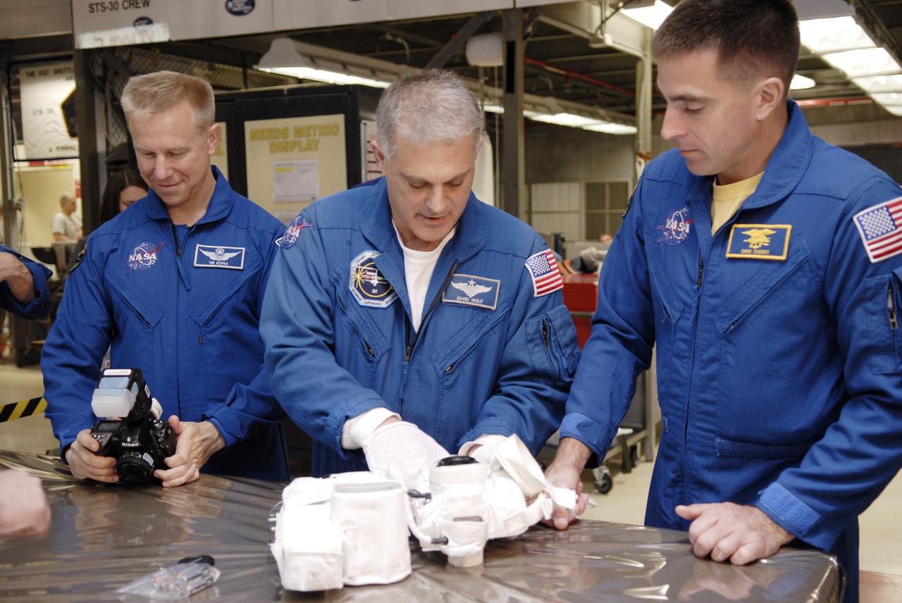 CAPE CANAVERAL, Fla. – In the Orbiter Processing Facility at NASA's Kennedy Space Center in Florida, astronauts with the STS-127 mission look at camera equipment they will use on the mission to the International Space Station. From left are Mission Specialists Tim Kopra, Dave Wolf and Christopher Cassidy. Kopra will remain with the Expedition 19 crew on the station. The crew members are at Kennedy for a crew equipment interface test, which provides hands-on training and observation of shuttle and flight hardware. Endeavour will deliver the Japanese Experiment Module's Experiment Logistics Module-Exposed Section, or ELM-ES, to the space station on STS-127. Launch is targeted for mid-June, 2009. Photo credit: NASA/Kim Shiflett