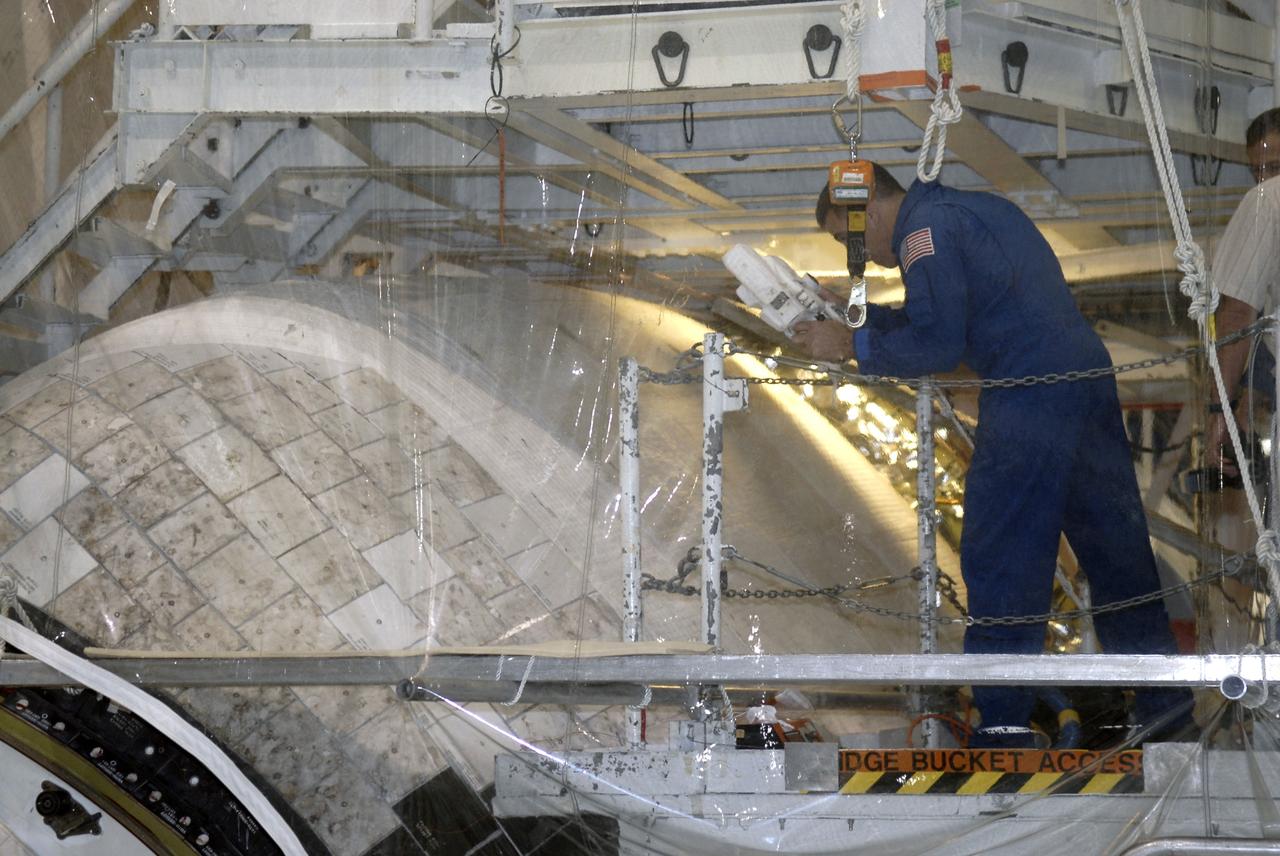 CAPE CANAVERAL, Fla. – In the Orbiter Processing Facility at NASA's Kennedy Space Center in Florida, STS-127 Mission Specialist Christopher Cassidy uses a camera for a close look at one of the main engines on space shuttle Endeavour. The crew members are at Kennedy for a crew equipment interface test, which provides hands-on training and observation of shuttle and flight hardware. Endeavour will deliver the Japanese Experiment Module's Experiment Logistics Module-Exposed Section, or ELM-ES, to the International Space Station on STS-127. Launch is targeted for mid-June, 2009. Photo credit: NASA/Kim Shiflett