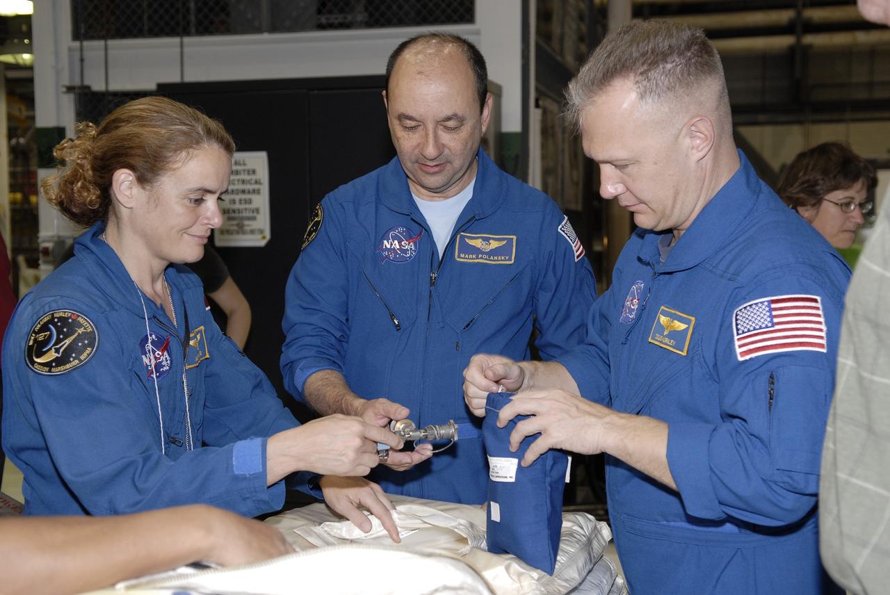 CAPE CANAVERAL, Fla. – In the Orbiter Processing Facility at NASA's Kennedy Space Center in Florida, STS-127 crew members examine equipment that will be on the mission. From left are Mission Specialist Julie Payette, Commander Mark Polansky and Pilot Doug Hurley. The crew members are at Kennedy for a crew equipment interface test, which provides hands-on training and observation of shuttle and flight hardware. Endeavour will deliver the Japanese Experiment Module's Experiment Logistics Module-Exposed Section, or ELM-ES, to the International Space Station on STS-127. Launch is targeted for mid-June, 2009. Photo credit: NASA/Kim Shiflett