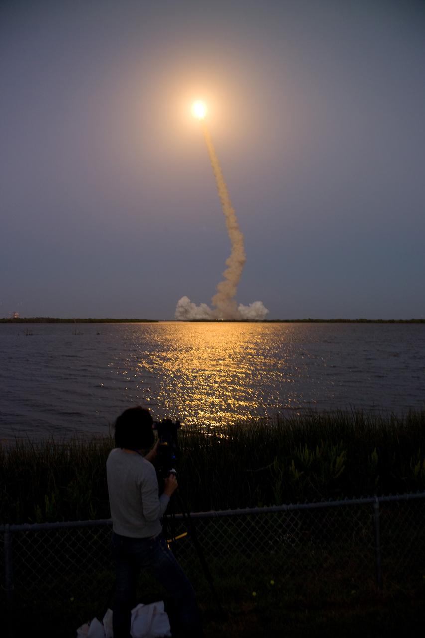 CAPE CANAVERAL, Fla. – Seen from the Banana River Viewing Site at NASA's Kennedy Space Center in Florida, space shuttle Discovery emulates a rising sun as it heads for space on the STS-119 mission. Liftoff from Launch Pad 39A was on time at 7:43 p.m. EDT. The STS-119 mission is the 28th to the space station and Discovery's 36th flight. Discovery will deliver the final pair of power-generating solar array wings and the S6 truss segment. Installation of S6 will signal the station's readiness to house a six-member crew for conducting increased science. Photo credit: NASA/Chris Lynch