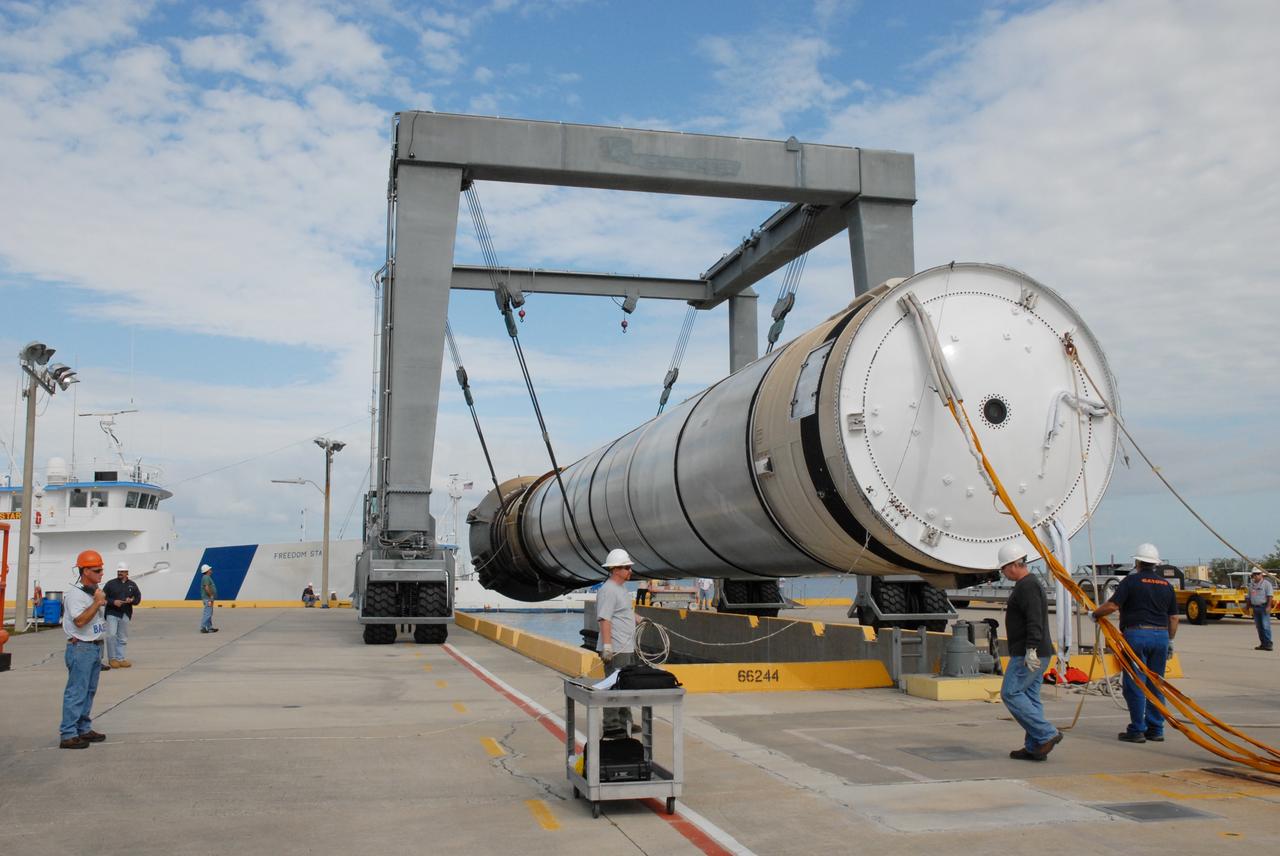 CAPE CANAVERAL, Fla. – At the dock at Hangar AF at Cape Canaveral Air Force Station in Florida, the solid rocket booster is lifted out of the water by the straddle crane.  The booster, used during space shuttle Discovery's launch from NASA's Kennedy Space Center in Florida March 15 on mission STS-119, will be placed on a transporter. The space shuttle’s solid rocket booster casings and associated flight hardware are recovered at sea after a launch. The spent rockets were recovered by NASA's Solid Rocket Booster Retrieval Ships Freedom Star and Liberty Star. The boosters impact the Atlantic Ocean approximately seven minutes after liftoff.  The splashdown area is a square of about six by nine nautical miles located about 140 nautical miles downrange from the launch pad. The retrieval ships are stationed approximately 8 to 10 nautical miles from the impact area at the time of splashdown. As soon as the boosters enter the water, the ships accelerate to a speed of 15 knots and quickly close on the boosters. The pilot chutes and main parachutes are the first items to be brought on board. With the chutes and frustum recovered, attention turns to the boosters. The ship’s tow line is connected and the booster is returned to the Port and, after transfer to a position alongside the ship, to Hangar AF. There, the expended boosters are disassembled, refurbished and reloaded with solid propellant for reuse.  Photo credit: NASA/Jack Pfaller