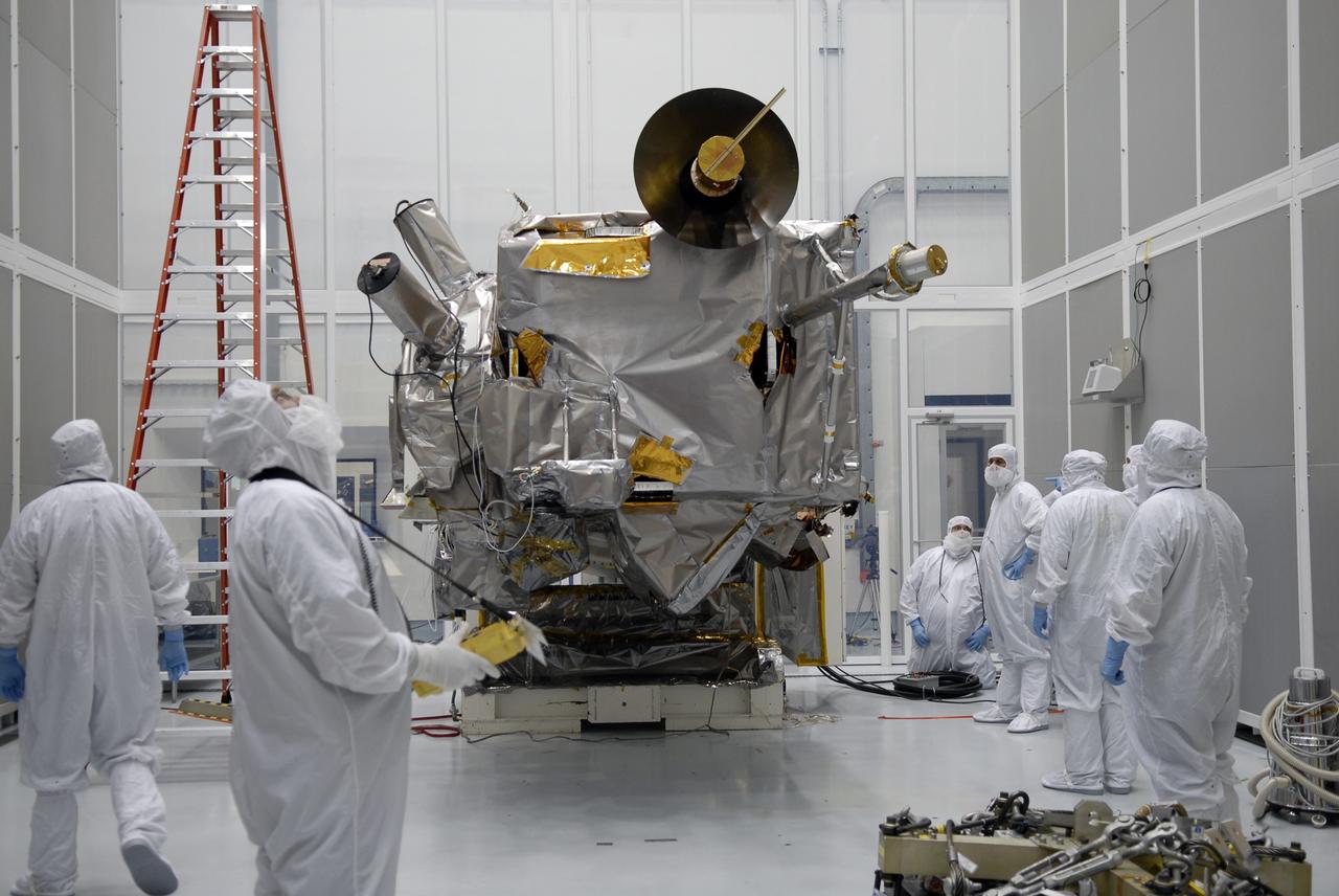 CAPE CANAVERAL, Fla. – At the Astrotech facility in Titusville, Fla., technicians wait for the rotation of NASA's Lunar Reconnaissance Orbiter, or LRO, (center) on the Aronson stand. When vertical, a crane will be attached to move the LRO to another stand. The orbiter will carry seven instruments to provide scientists with detailed maps of the lunar surface and enhance our understanding of the moon's topography, lighting conditions, mineralogical composition and natural resources. Information gleaned from LRO will be used to select safe landing sites, determine locations for future lunar outposts and help mitigate radiation dangers to astronauts. The polar regions of the moon are the main focus of the mission because continuous access to sunlight may be possible and water ice may exist in permanently shadowed areas of the poles. Accompanying LRO on its journey to the moon will be the Lunar CRater Observation and Sensing Satellite, or LCROSS, a mission that will impact the lunar surface in its search for water ice. Launch of LRO is targeted for May 20. Photo credit: NASA/Kim Shiflett