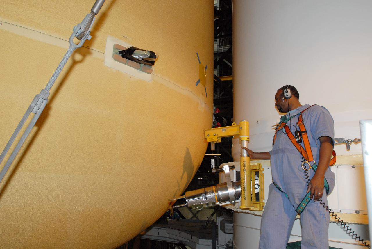CAPE CANAVERAL, Fla. – – In the Vehicle Assembly Building at NASA's Kennedy Space Center in Florida, a technician oversees the movement of space shuttle Endeavour's external fuel tank as it is lowered onto the mobile launcher platform. Endeavour will deliver the Japanese Experiment Module's Experiment Logistics Module-Exposed Section, or ELM-ES, to the International Space Station on STS-127. Launch is targeted for mid-June 2009. Photo credit: NASA/Jim Grossmann
