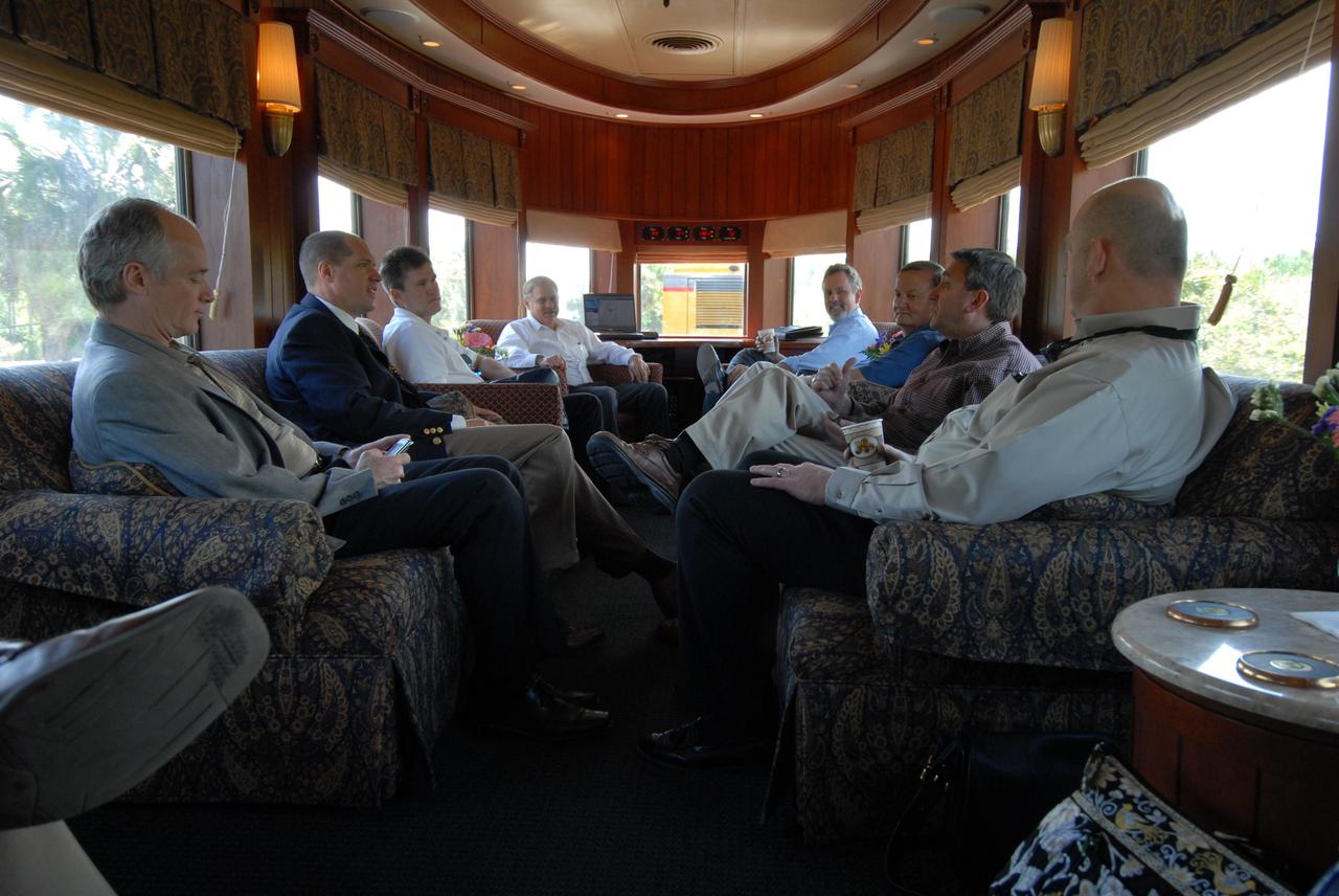 CAPE CANAVERAL, Fla. – ATK and NASA officials accompanied the Florida East Coast Railroad train carrying the booster segments for the Ares I-X test rocket on its route to NASA's Kennedy Space Center in Florida from Jacksonville, Fla.  Seen here in the passenger car are, from left, ATK Vice President Space Launch Systems Charlie Precourt, a Florida East Coast Railroad representative, ATK Deputy Site Director in Florida Ted Shaffner, ATK Vice President Of Space Launch Propulsion Cary Ralston,  NASA KSC Shuttle Launch Director Mike Leinbach, a Florida East Coast Railroad representative and  ATK Ares I First Stage program Director Fred Brasfield. The four reusable motor segments and the nozzle exit cone, manufactured by the Ares I first-stage prime contractor Alliant Techsystems Inc., or ATK, departed Utah March 12 on the seven-day, cross-country trip to Florida.  The segments will be delivered to the  Rotation, Processing and Surge Facility for final processing and integration. The booster used for the Ares I-X launch is being modified by adding new forward structures and a fifth segment simulator. The motor is the final hardware needed for the rocket's upcoming test flight this summer. The stacking operations are scheduled to begin in the Vehicle Assembly Building in April.   Photo credit: NASA/Kim Shiflett