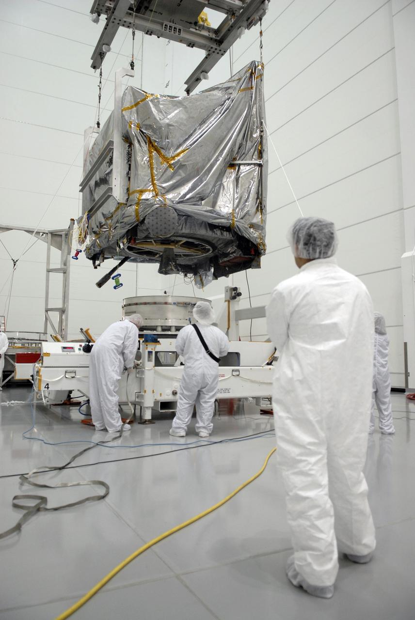 CAPE CANAVERAL, Fla. – At the Astrotech payload processing facility in Titusville, Fla., the GOES-O satellite is lowered toward a stand. The satellite will undergo final testing of the imaging system, instrumentation, communications and power systems. The latest Geostationary Operational Environmental Satellite, GOES-O was developed by NASA for the National Oceanic and Atmospheric Administration, or NOAA. The GOES-O satellite is targeted to launch April 28 onboard a United Launch Alliance Delta IV expendable launch vehicle. Once in orbit, GOES-O will be designated GOES-14, and NASA will provide on-orbit checkout and then transfer operational responsibility to NOAA. GOES-O will be placed in on-orbit storage as a replacement for an older GOES satellite. GOES-O carries an advanced attitude control system using star trackers with spacecraft optical bench Imager and Sounder mountings that provide enhanced instrument pointing performance for improved image navigation and registration to better locate severe storms and other events important to the NOAA National Weather Service. Photo credit: NASA/Kim Shiflett
