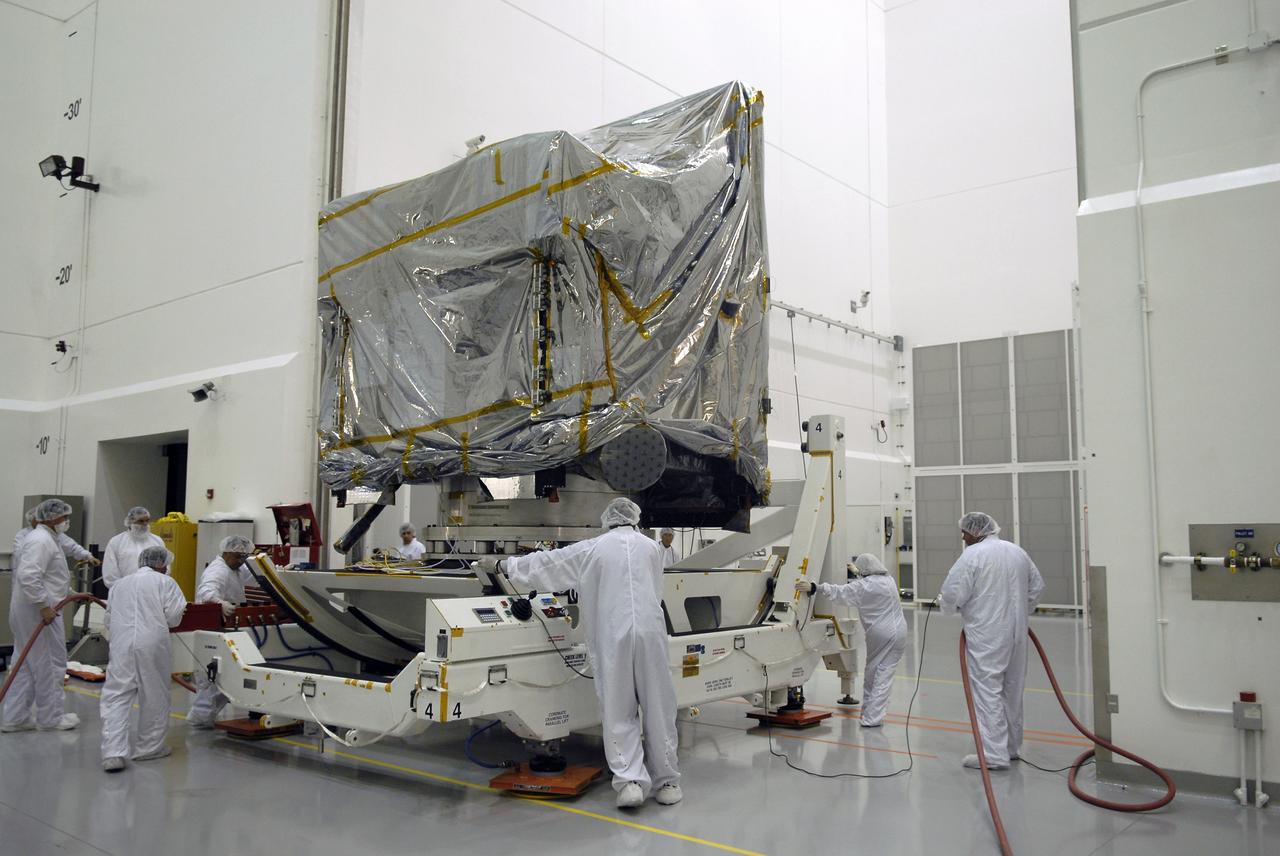 CAPE CANAVERAL, Fla. – At the Astrotech payload processing facility in Titusville, Fla., technicians move the test stand with the GOES-O satellite. The satellite will undergo final testing of the imaging system, instrumentation, communications and power systems. The latest Geostationary Operational Environmental Satellite, GOES-O was developed by NASA for the National Oceanic and Atmospheric Administration, or NOAA. The GOES-O satellite is targeted to launch April 28 onboard a United Launch Alliance Delta IV expendable launch vehicle. Once in orbit, GOES-O will be designated GOES-14, and NASA will provide on-orbit checkout and then transfer operational responsibility to NOAA. GOES-O will be placed in on-orbit storage as a replacement for an older GOES satellite. GOES-O carries an advanced attitude control system using star trackers with spacecraft optical bench Imager and Sounder mountings that provide enhanced instrument pointing performance for improved image navigation and registration to better locate severe storms and other events important to the NOAA National Weather Service. Photo credit: NASA/Kim Shiflett