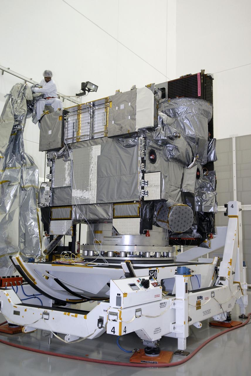 CAPE CANAVERAL, Fla. – At the Astrotech payload processing facility in Titusville, Fla., technicians remove the protective cover wrapped around the GOES-O satellite. The satellite will undergo final testing of the imaging system, instrumentation, communications and power systems. The latest Geostationary Operational Environmental Satellite, GOES-O was developed by NASA for the National Oceanic and Atmospheric Administration, or NOAA. The GOES-O satellite is targeted to launch April 28 onboard a United Launch Alliance Delta IV expendable launch vehicle. Once in orbit, GOES-O will be designated GOES-14, and NASA will provide on-orbit checkout and then transfer operational responsibility to NOAA. GOES-O will be placed in on-orbit storage as a replacement for an older GOES satellite. GOES-O carries an advanced attitude control system using star trackers with spacecraft optical bench Imager and Sounder mountings that provide enhanced instrument pointing performance for improved image navigation and registration to better locate severe storms and other events important to the NOAA National Weather Service. Photo credit: NASA/Kim Shiflett