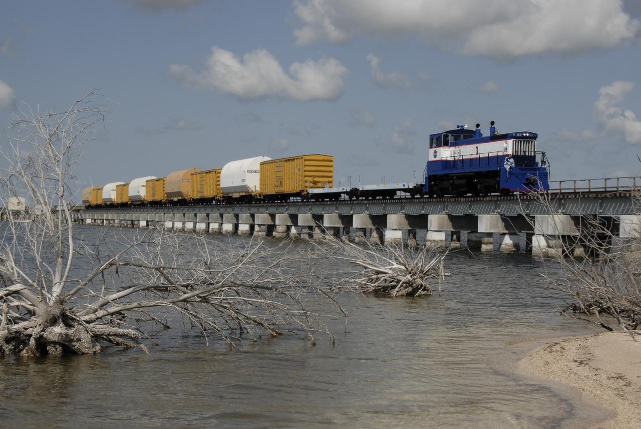 CAPE CANAVERAL, Fla. – The NASA Railroad hauls cars carrying the Ares I-X motor segments and nozzle exit cone over a river bridge to NASA's Kennedy Space Center in Florida. The four reusable motor segments and the nozzle exit cone, manufactured by the Ares I first-stage prime contractor Alliant Techsystems Inc., or ATK, departed Utah March 12 on the seven-day, cross-country trip to Florida.  The segments will be delivered to Kennedy's  Rotation, Processing and Surge Facility for final processing and integration. The booster used for the Ares I-X launch is being modified by adding new forward structures and a fifth segment simulator. The motor is the final hardware needed for the rocket's upcoming test flight this summer. The stacking operations are scheduled to begin in the Vehicle Assembly Building in April.   Photo credit: NASA/Kim Shiflett
