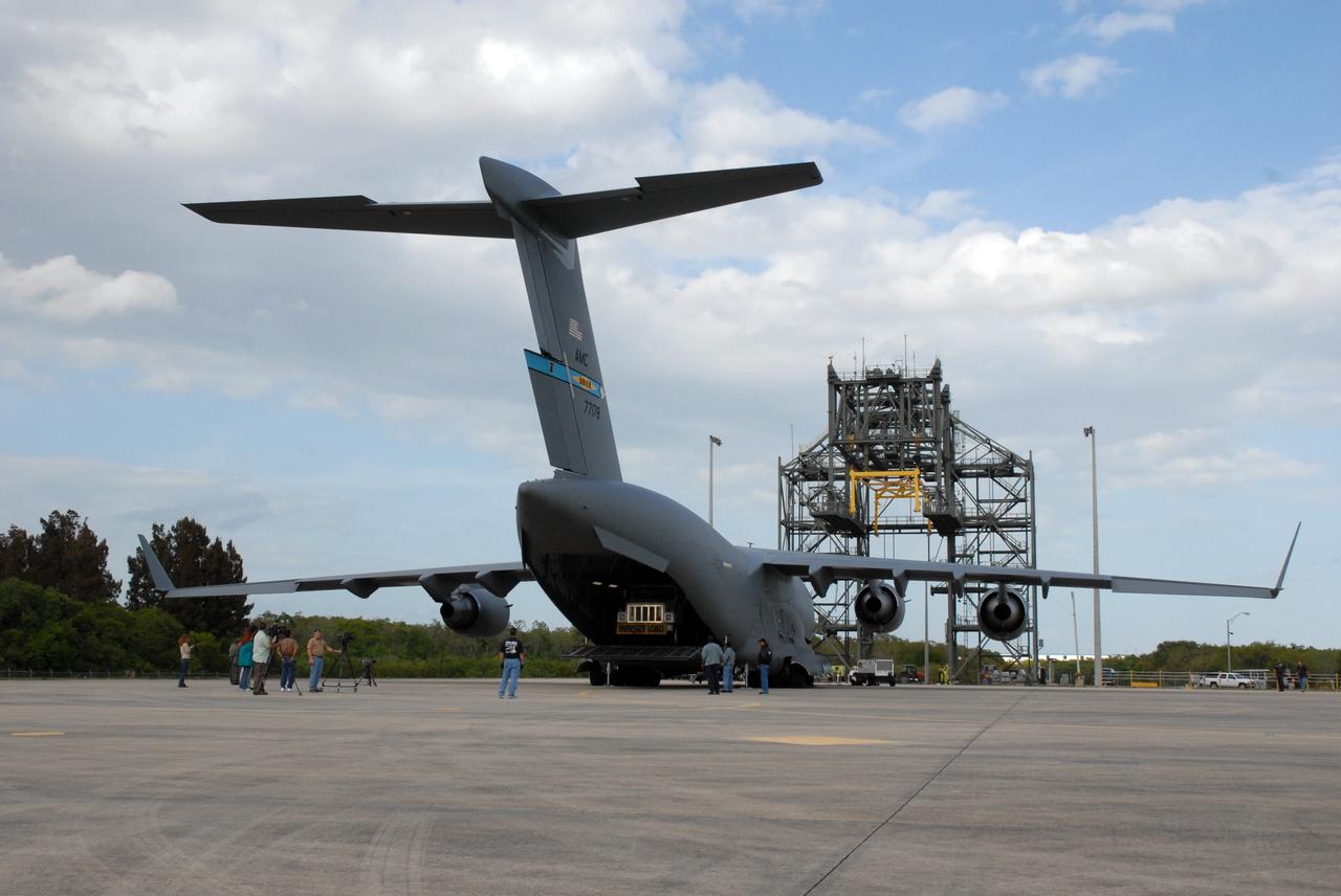 CAPE CANAVERAL, Fla. – A C-17 cargo plane arrives at the Shuttle Landing Facility at NASA's Kennedy Space Center in Florida with its cargo of the EXPRESS Logistics Carrier for the STS-129 mission. In the background is the mate/demate device used to separate a space shuttle from the Shuttle Carrier Aircraft. The carrier is part of the payload on space shuttle Atlantis, which will deliver to the International Space Station components including two spare gyroscopes, two nitrogen tank assemblies, two pump modules, an ammonia tank assembly and a spare latching end effector for the station's robotic arm. STS-129 is targeted to launch Nov. 12. Photo credit: NASA/Tim Jacobs