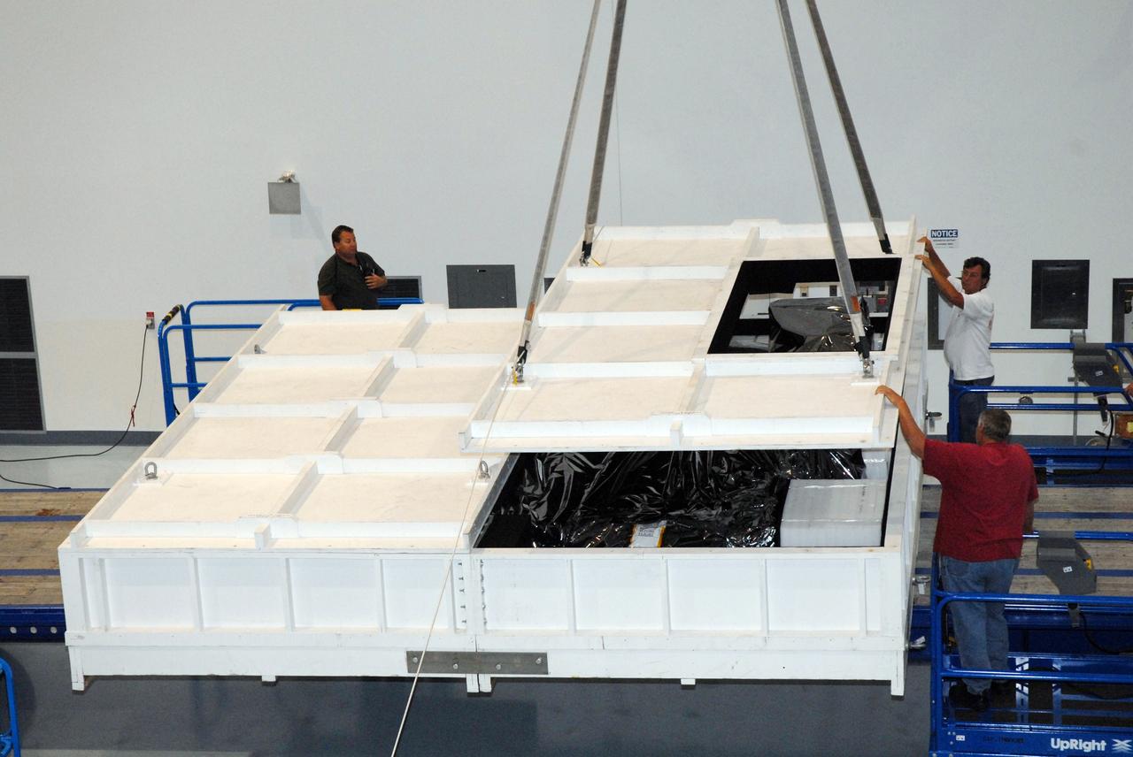 CAPE CANAVERAL, Fla. – Inside the Space Station Processing Facility at NASA's Kennedy Space Center in Florida, workers begin removing the shipping container from around the EXPRESS Logistics Carrier for the STS-129 mission. The carrier is part of the payload on space shuttle Atlantis, which will deliver to the International Space Station components including two spare gyroscopes, two nitrogen tank assemblies, two pump modules, an ammonia tank assembly and a spare latching end effector for the station's robotic arm.  STS-129 is targeted to launch Nov. 12.  Photo credit: NASA/Tim Jacobs