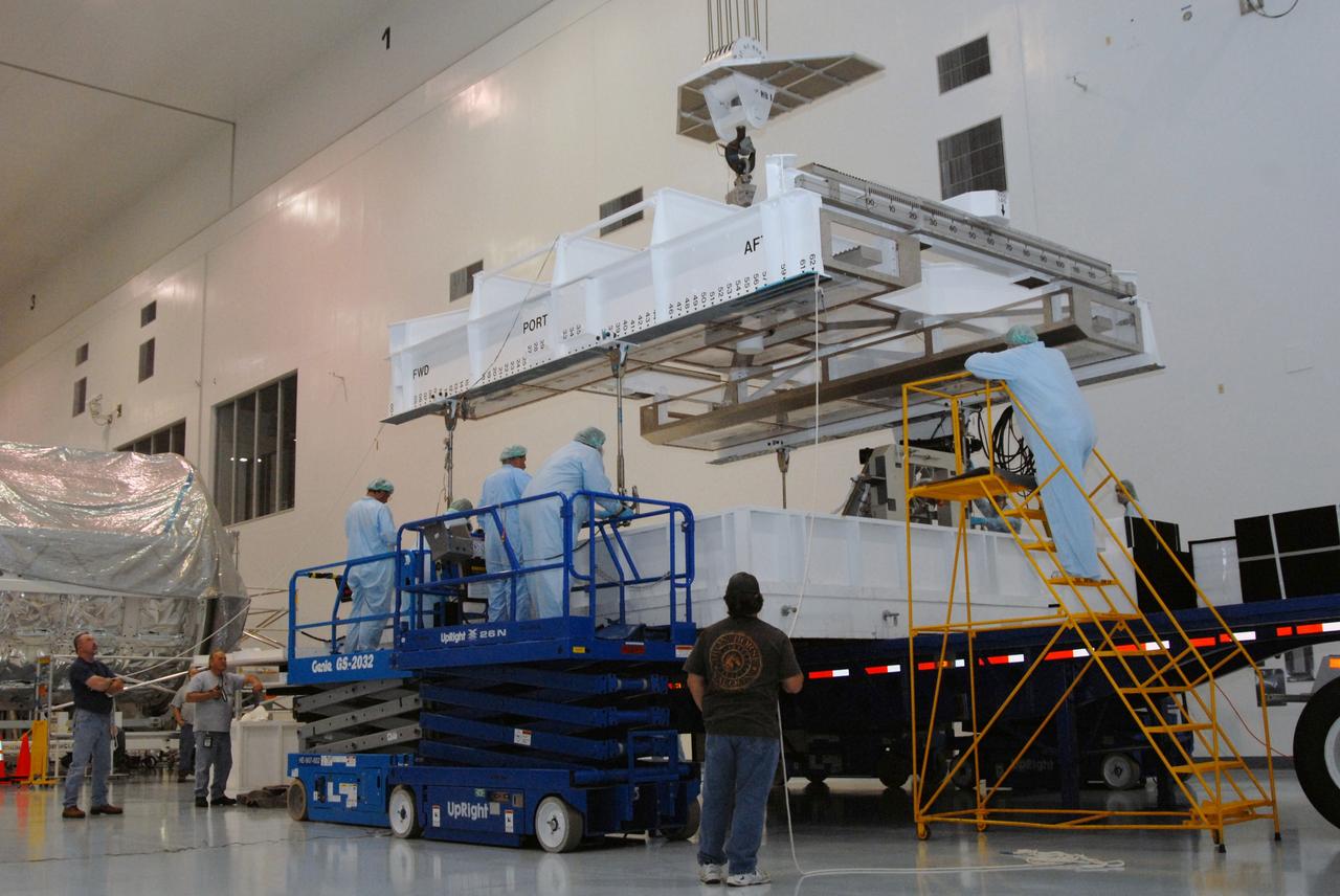 CAPE CANAVERAL, Fla. – Inside the Space Station Processing Facility at NASA's Kennedy Space Center in Florida, a strongback crane is lowered toward the EXPRESS Logistics Carrier to lift it to a stand. The carrier is part of the payload on space shuttle Atlantis, which will deliver to the International Space Station components including two spare gyroscopes, two nitrogen tank assemblies, two pump modules, an ammonia tank assembly and a spare latching end effector for the station's robotic arm.  STS-129 is targeted to launch Nov. 12.  Photo credit: NASA/Tim Jacobs