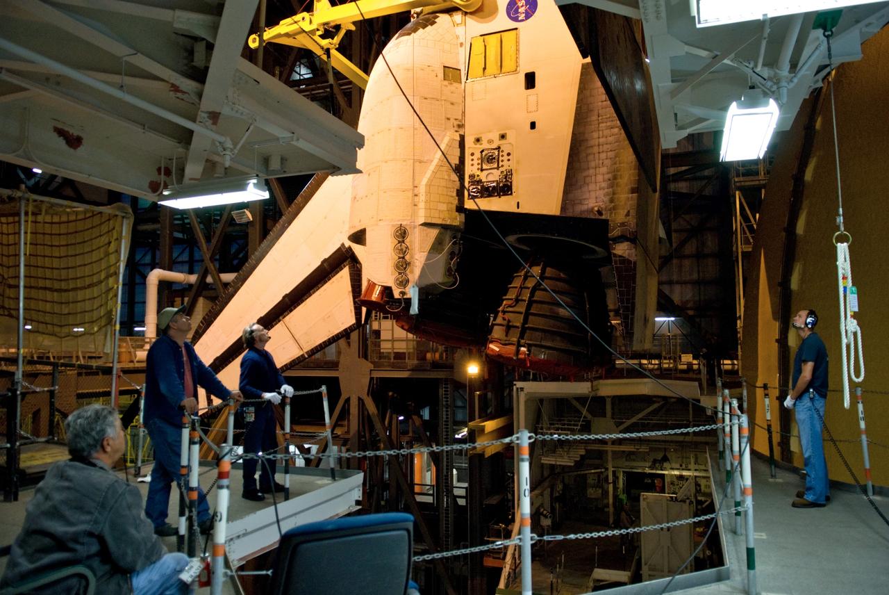 CAPE CANAVERAL, Fla. – In the Vehicle Assembly Building at NASA's Kennedy Space Center in Florida, workers observe the movement of space shuttle Atlantis as it is lowered toward the mobile launcher platform. The shuttle will be mated with the external fuel tank and solid rocket boosters on the platform. After additional preparations are made, the shuttle will be rolled out to Launch Pad 39A for a targeted launch on May 12 on the STS-125 mission to service NASA's Hubble Space Telescope. Photo credit: NASA/Kim Shiflett