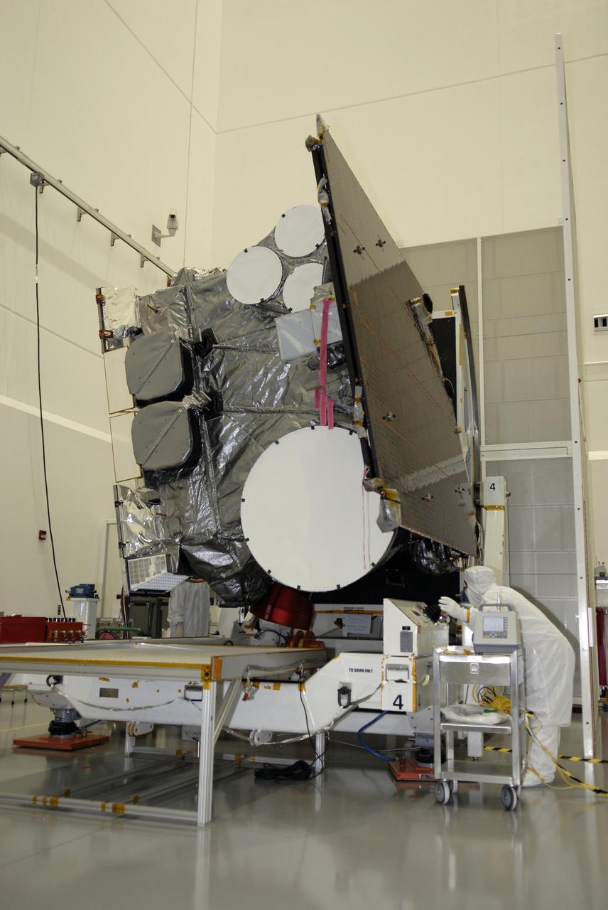 CAPE CANAVERAL, Fla. – At the Astrotech payload processing facility in Titusville, Fla., a technician checks the GOES-O satellite as it begins rotating on the stand. The latest Geostationary Operational Environmental Satellite, GOES-O was developed by NASA for the National Oceanic and Atmospheric Administration, or NOAA. Once in orbit, GOES-O will be designated GOES-14, and NASA will provide on-orbit checkout and then transfer operational responsibility to NOAA. The GOES-O satellite is targeted to launch April 28 onboard a United Launch Alliance Delta IV expendable launch vehicle.  Photo credit: NASA/Kim Shiflett