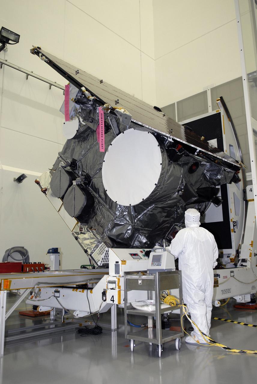 CAPE CANAVERAL, Fla. – At the Astrotech payload processing facility in Titusville, Fla., ., a technician checks the GOES-O satellite as it rotates on the stand. The latest Geostationary Operational Environmental Satellite, GOES-O was developed by NASA for the National Oceanic and Atmospheric Administration, or NOAA. Once in orbit, GOES-O will be designated GOES-14, and NASA will provide on-orbit checkout and then transfer operational responsibility to NOAA. The GOES-O satellite is targeted to launch April 28 onboard a United Launch Alliance Delta IV expendable launch vehicle.  Photo credit: NASA/Kim Shiflett